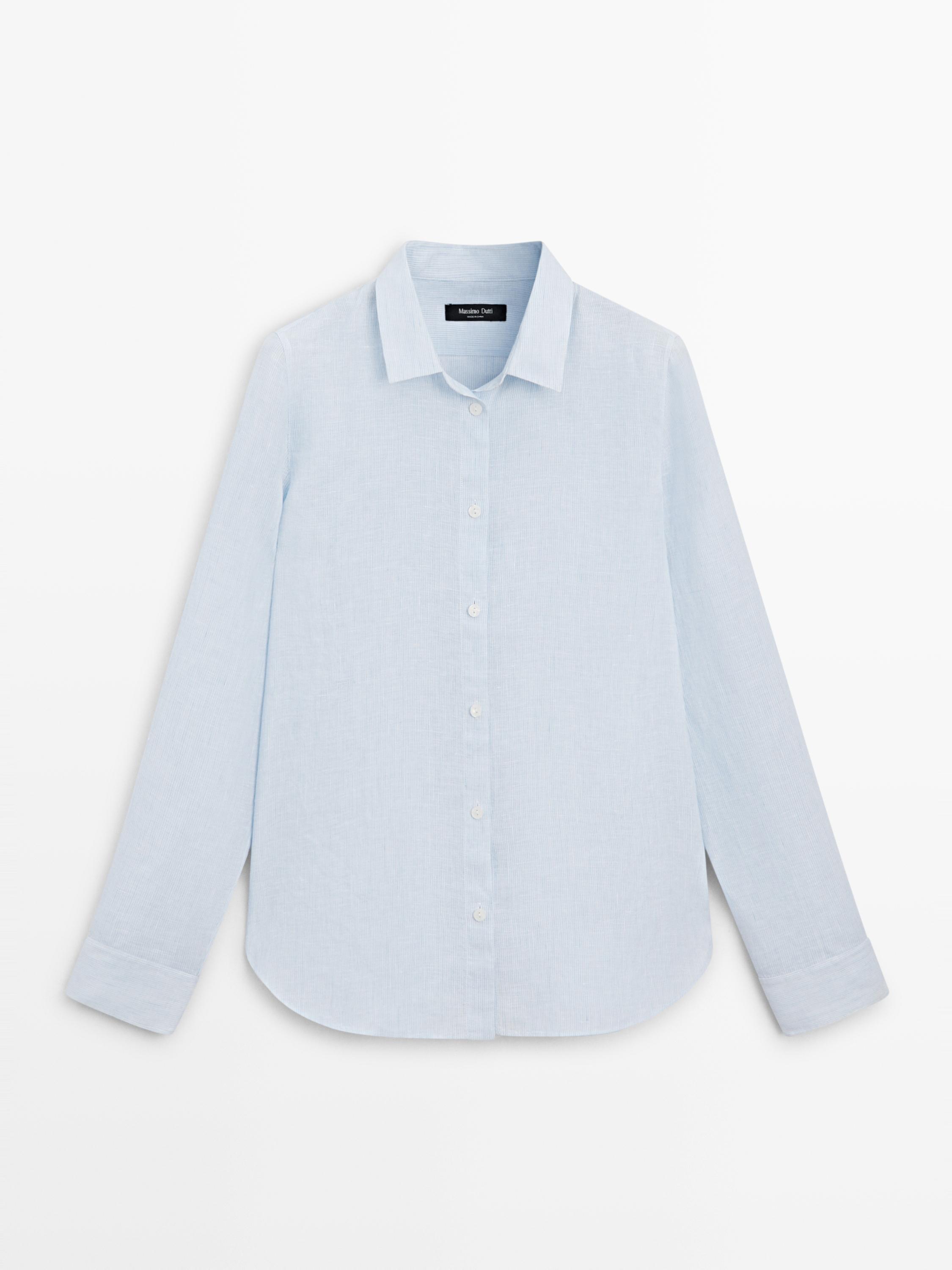 Vista frontal de camisa azul cielo de rayas finas, corte clásico, cuello camisero, manga larga y abotonadura central.