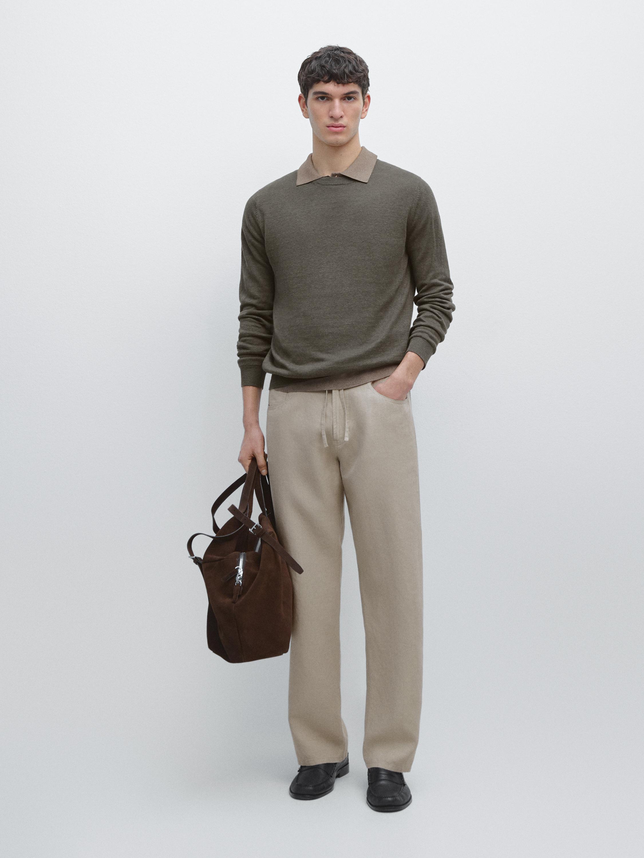 Conjunto de pantalón beige con bolsillos laterales y suéter verde oliva de cuello polo.
