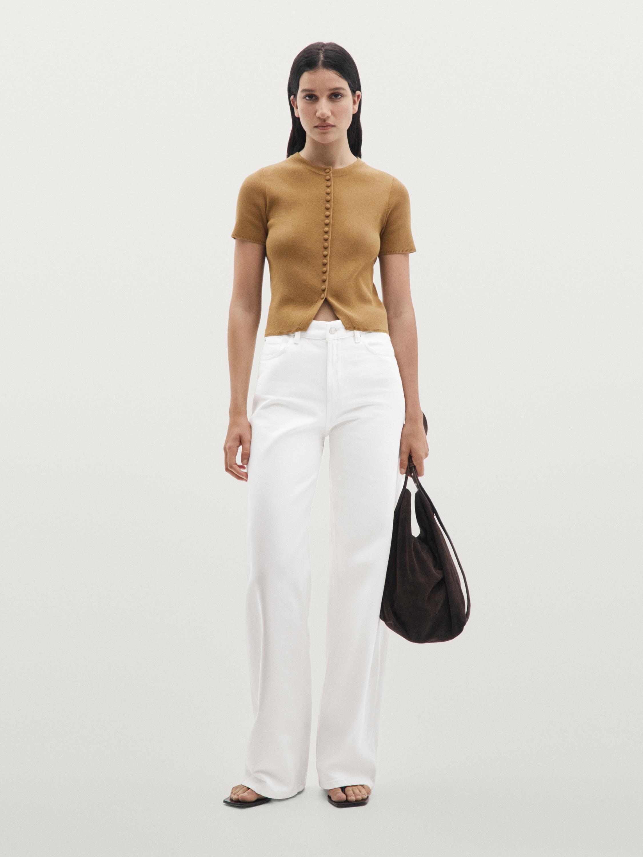 Set aus vanillefarbenem, kurzärmeligem Cardigan mit Knöpfen und weißer weiter Hose.