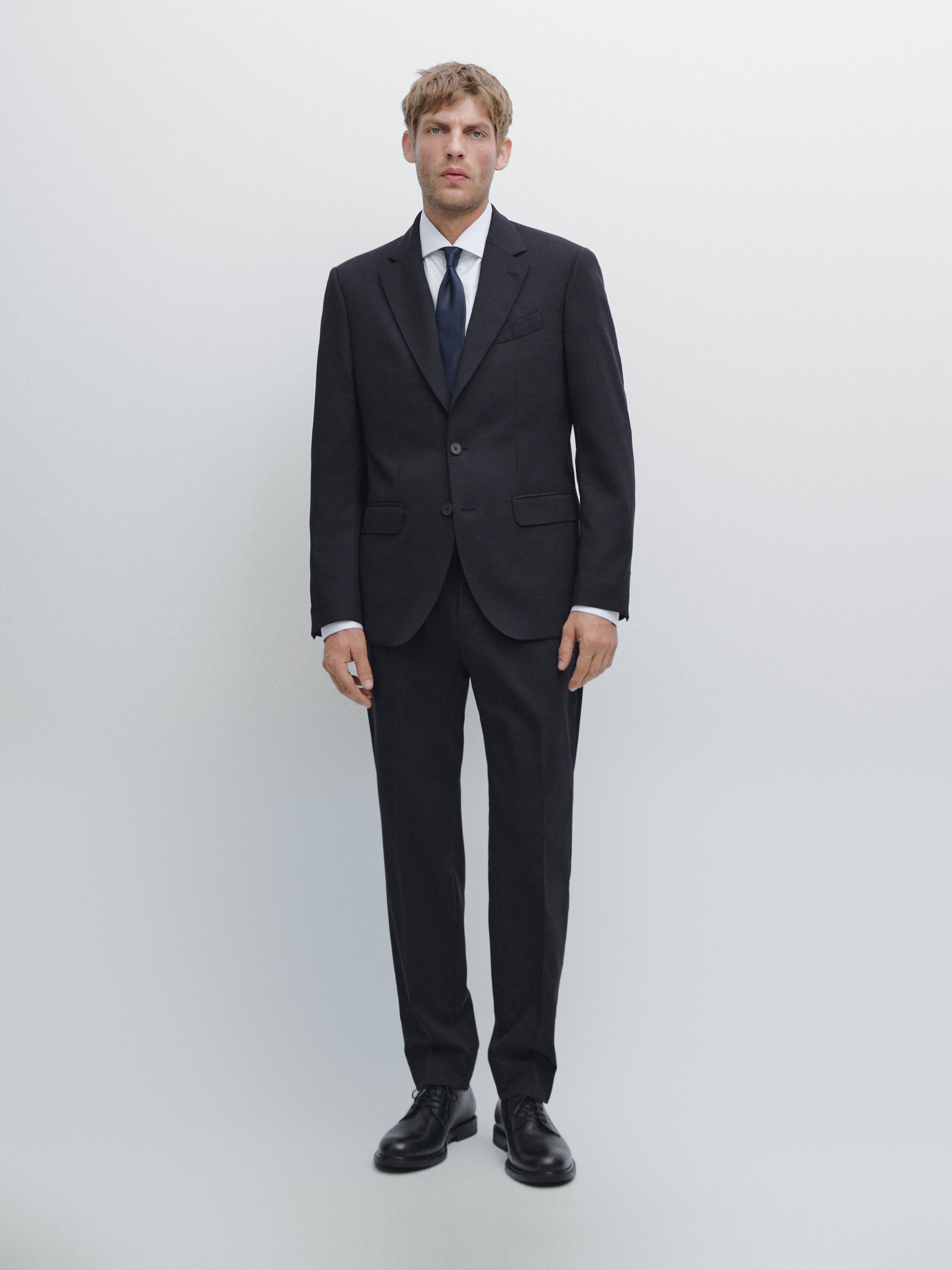 Ensemble de costume bleu marine avec veste à deux boutons, pantalon de tailleur et cravate bleu foncé.