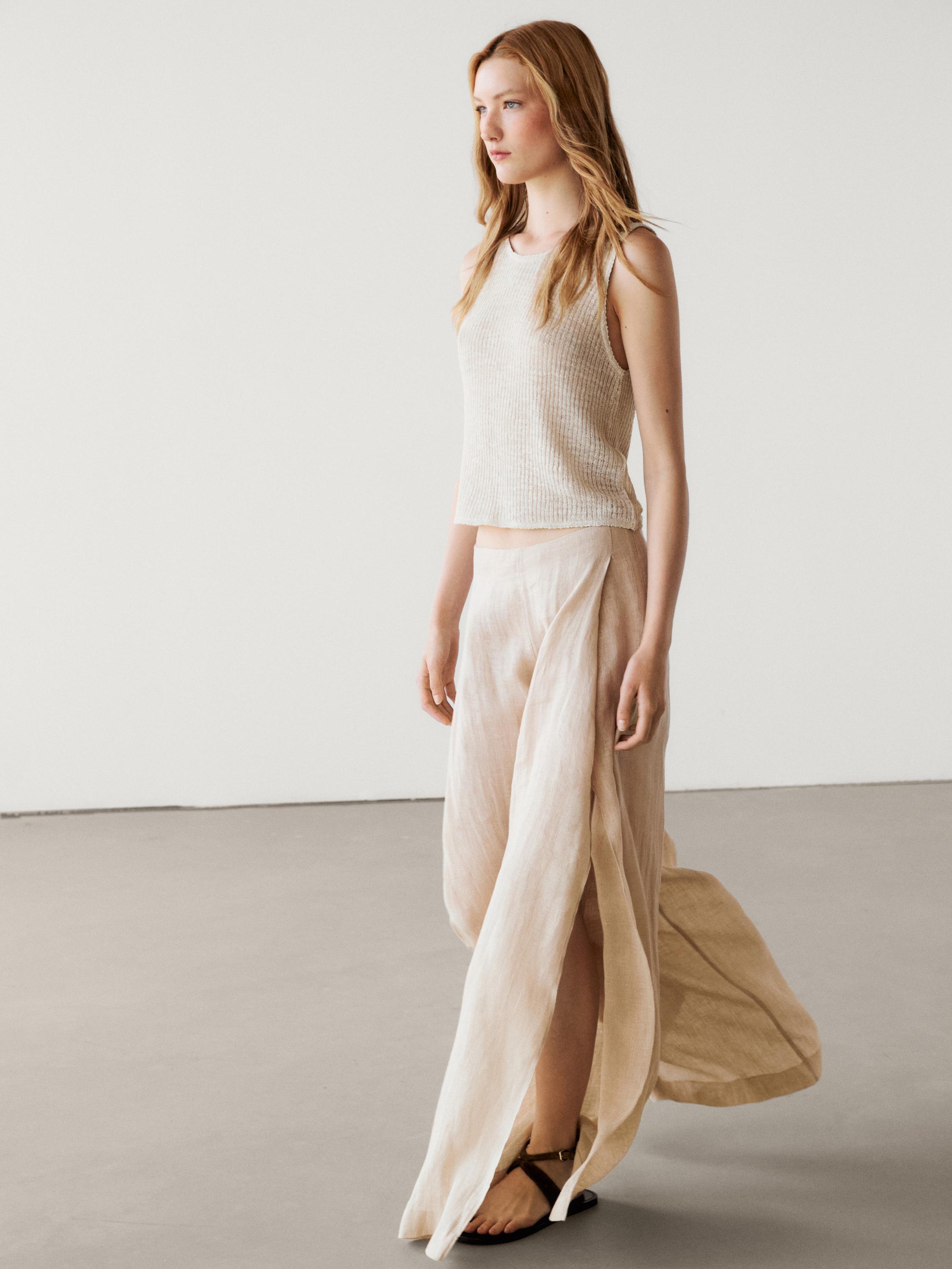 طقم توب بدون أكمام بيج وتنورة طويلة بفتحة جانبية.