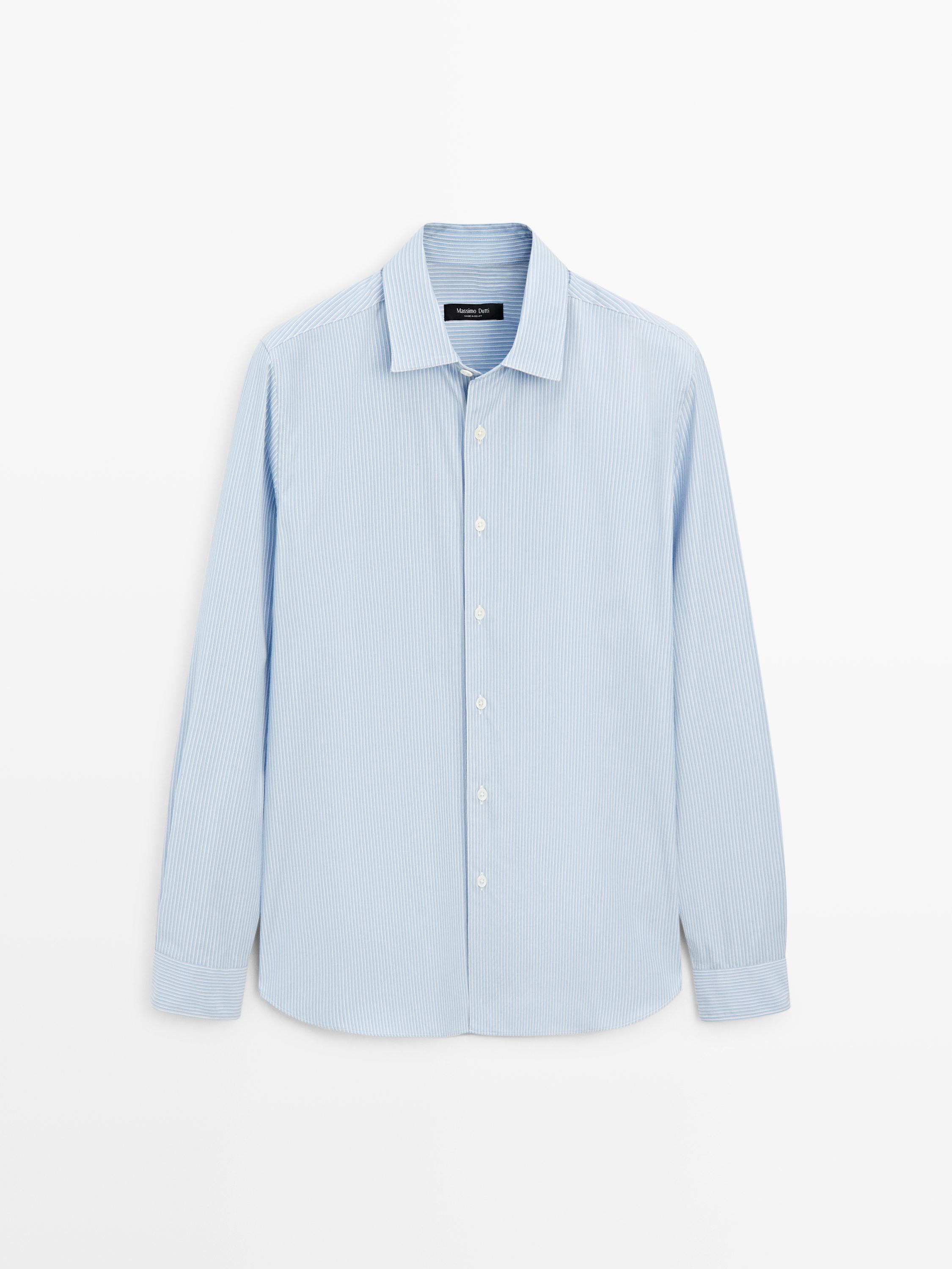 Önden görünüm, beyaz düğmeli ve klasik yakalı, açık mavi uzun kollu gömlek.