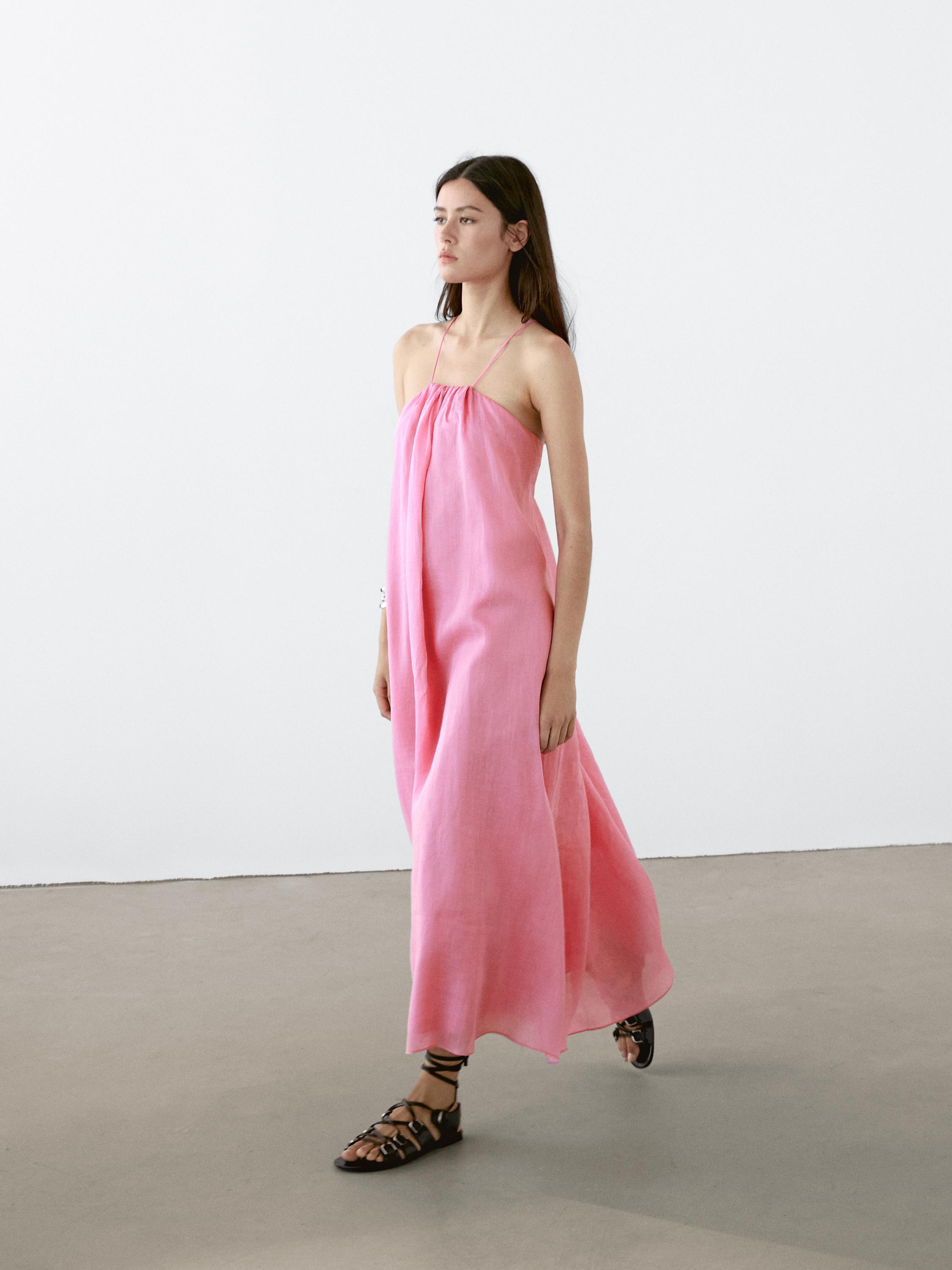 Ensemble composé d'une longue robe rose sans manches à fines bretelles et de sandales noires.