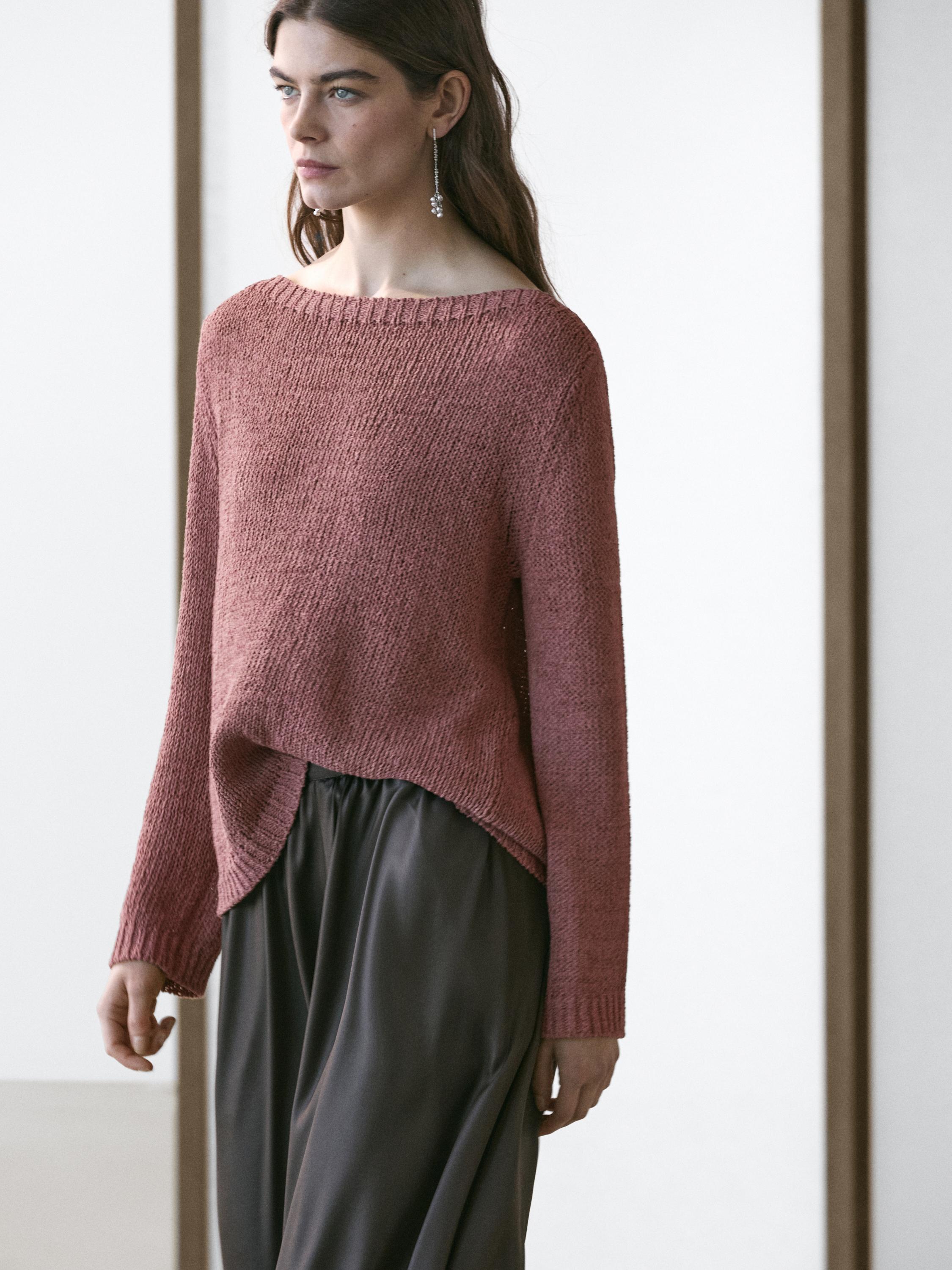 Puntu arrosazko jertse-multzoa, lepo-ontzia eta mahuka luzeak dituena, praka ilun zabalekin konbinatuta.