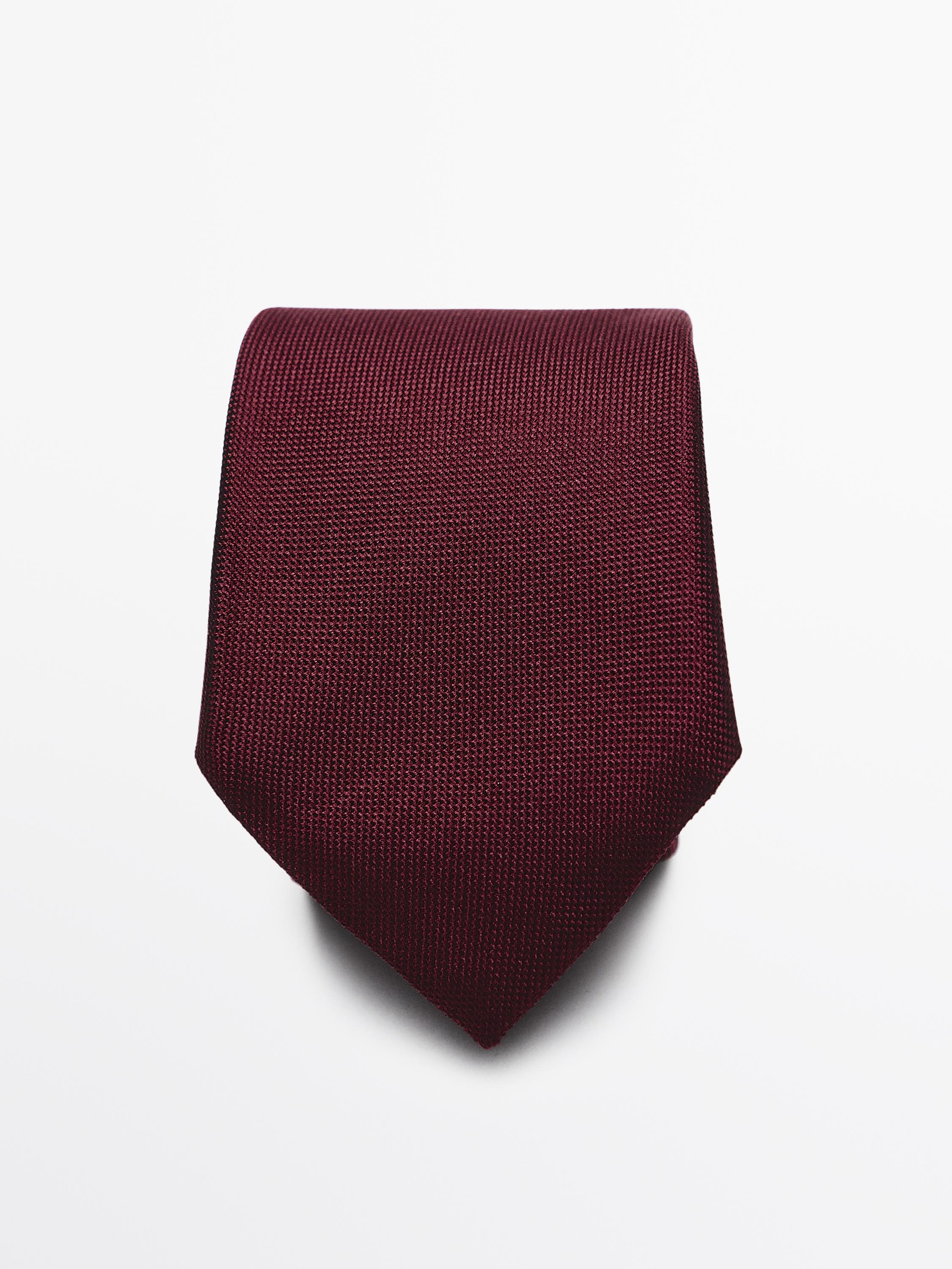 Вид спереди на бордовый галстук с текстурной структурой.