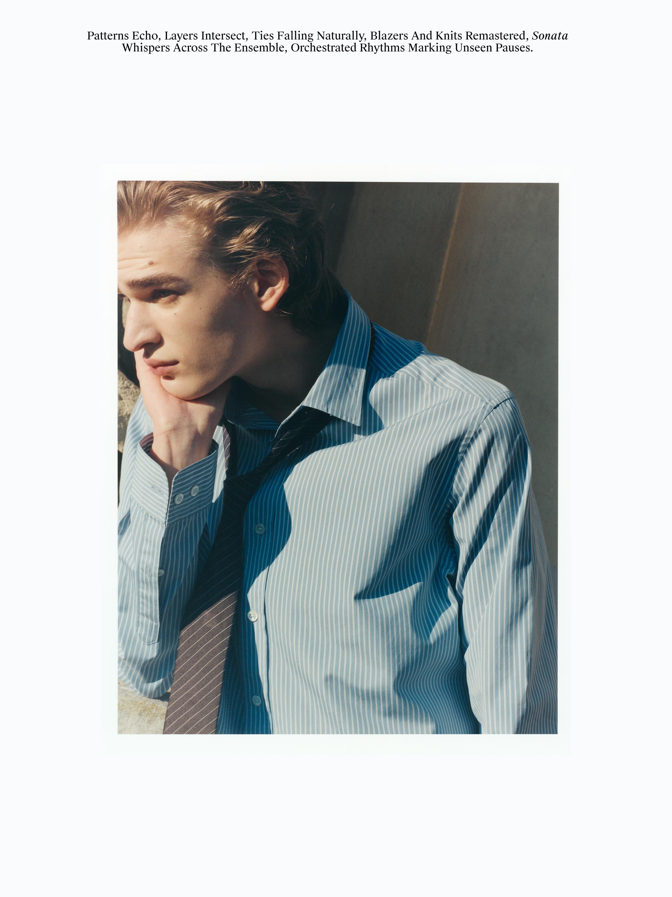 Marra urdineko alkandora klasikoa, lepo klasikoa eta botoi agerikoak dituena, marra diagonaleko gorbata batekin konbinatuta.