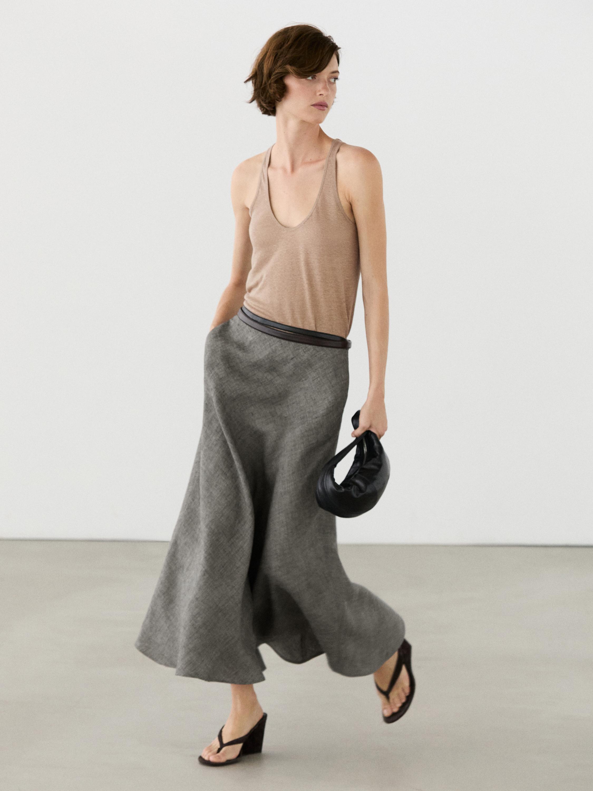 Gray flared midi skirt and sleeveless beige top set.