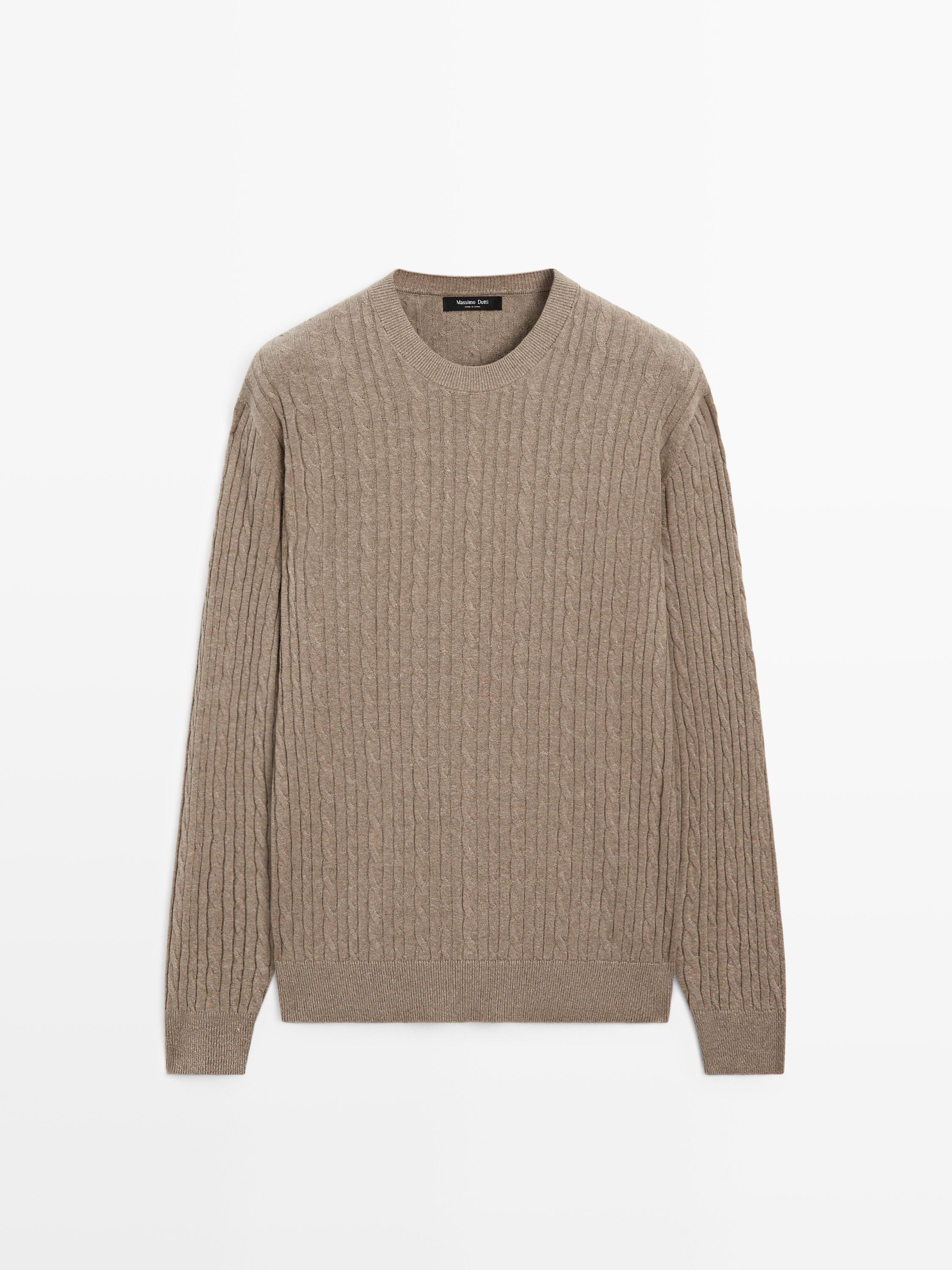 Front view of a light khaki cable-knit sweater with a round neck and long sleeves.