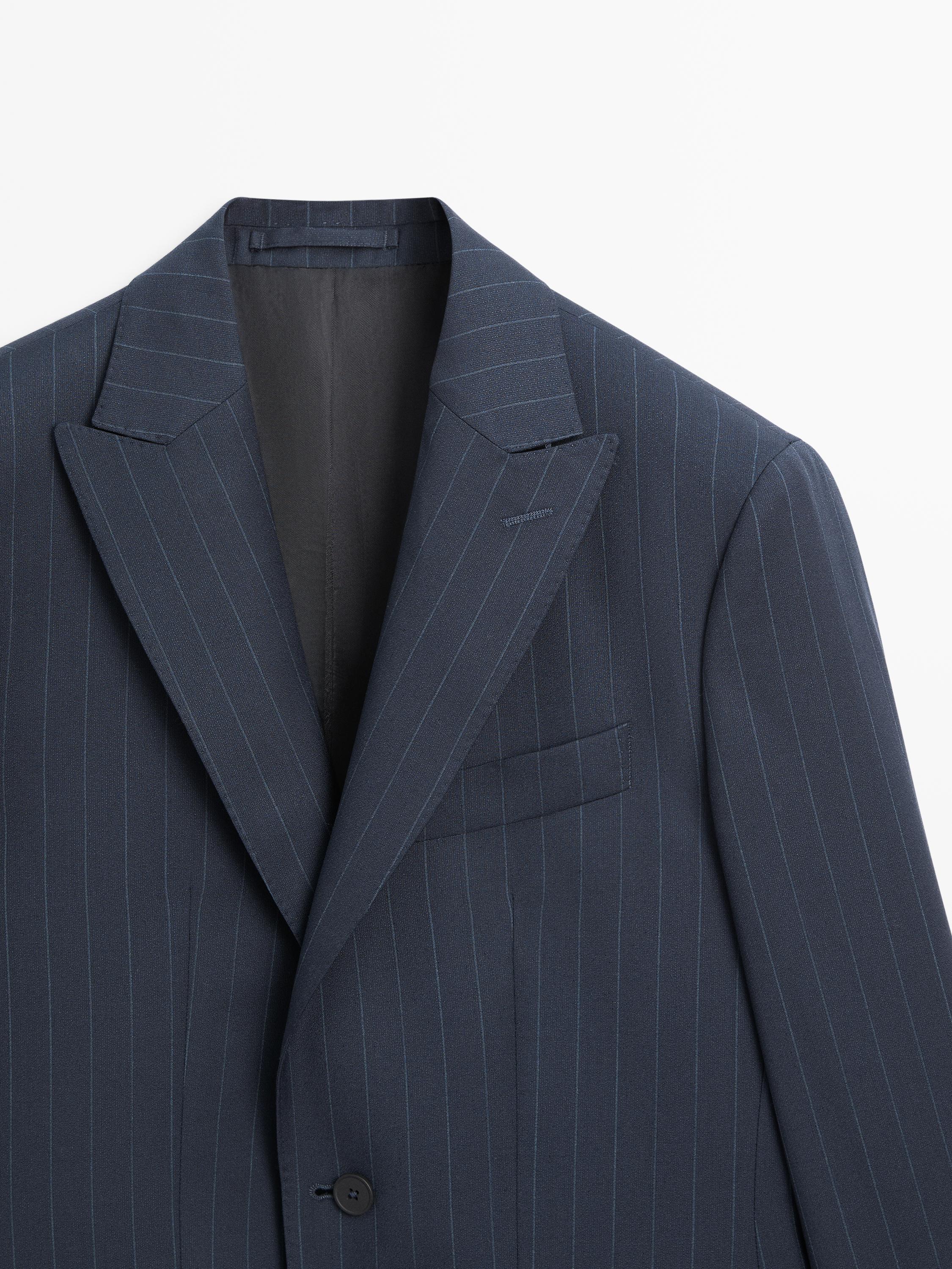 "Mid-shot of a navy blue blazer with fine stripes, notch lapels, and a chest pocket."
