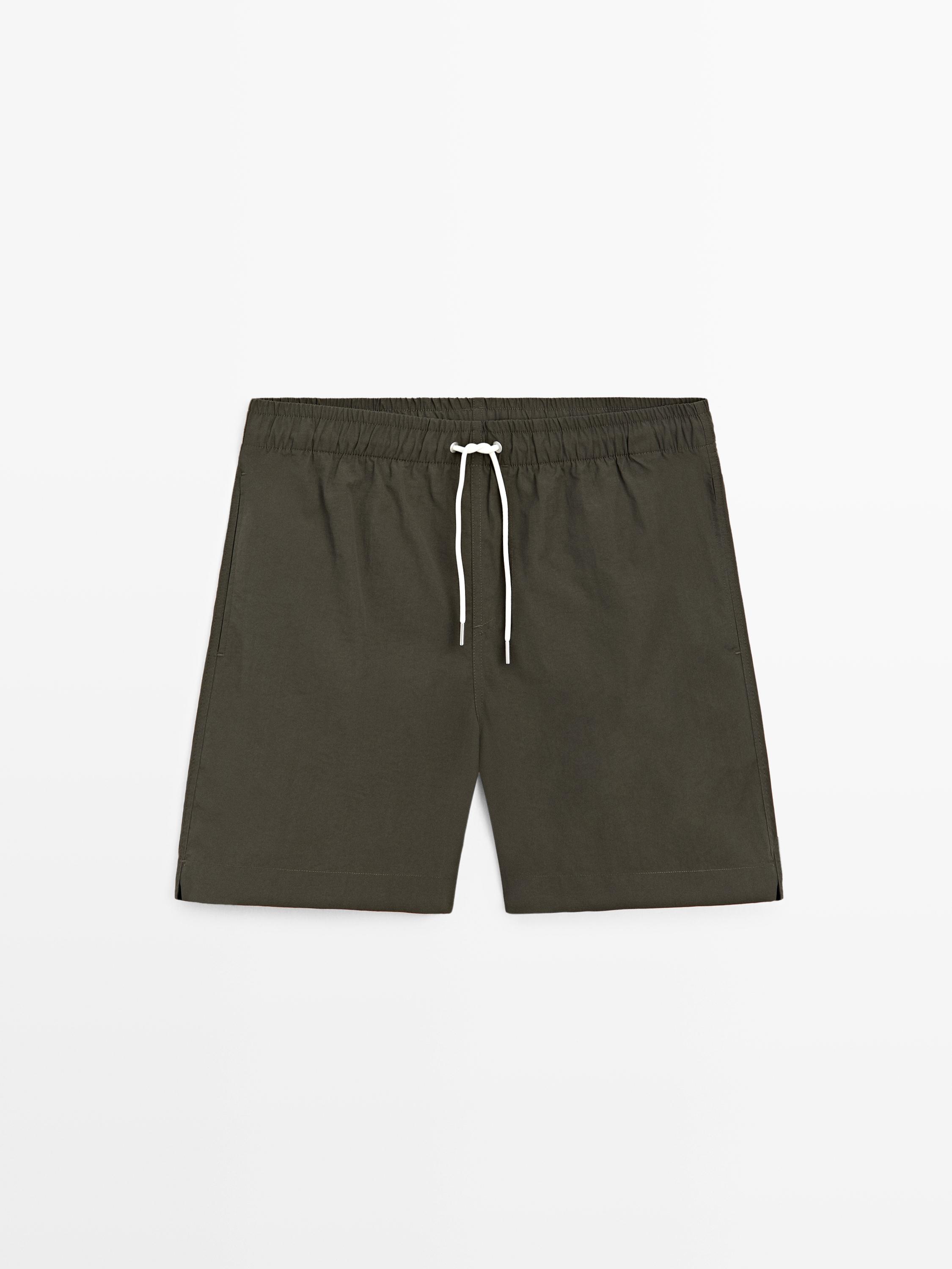 Vorderansicht einer khakifarbenen Badehose mit elastischem Bund und weißem Kordelzug.