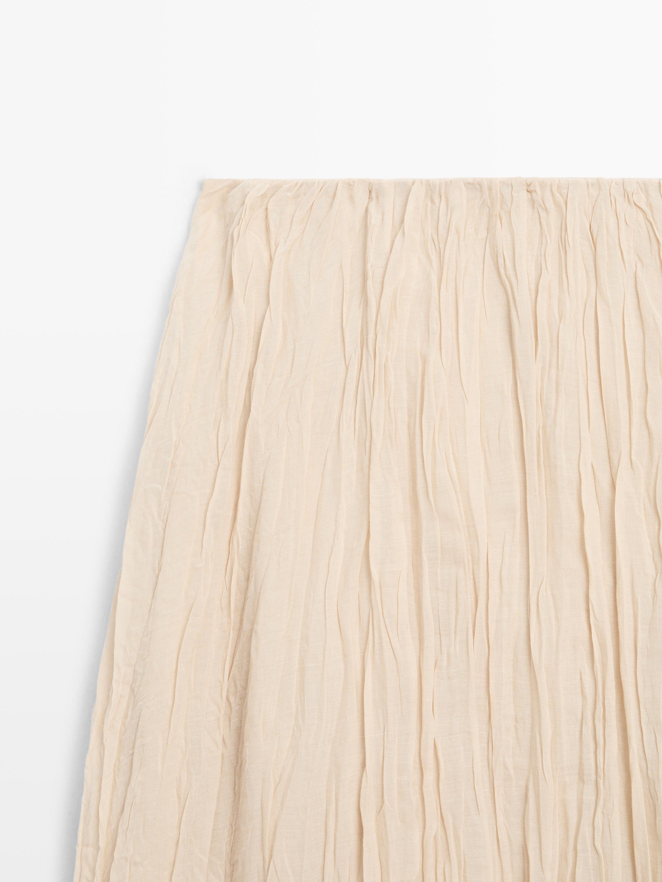 "Detalle de saia midi crua con prego fluído."