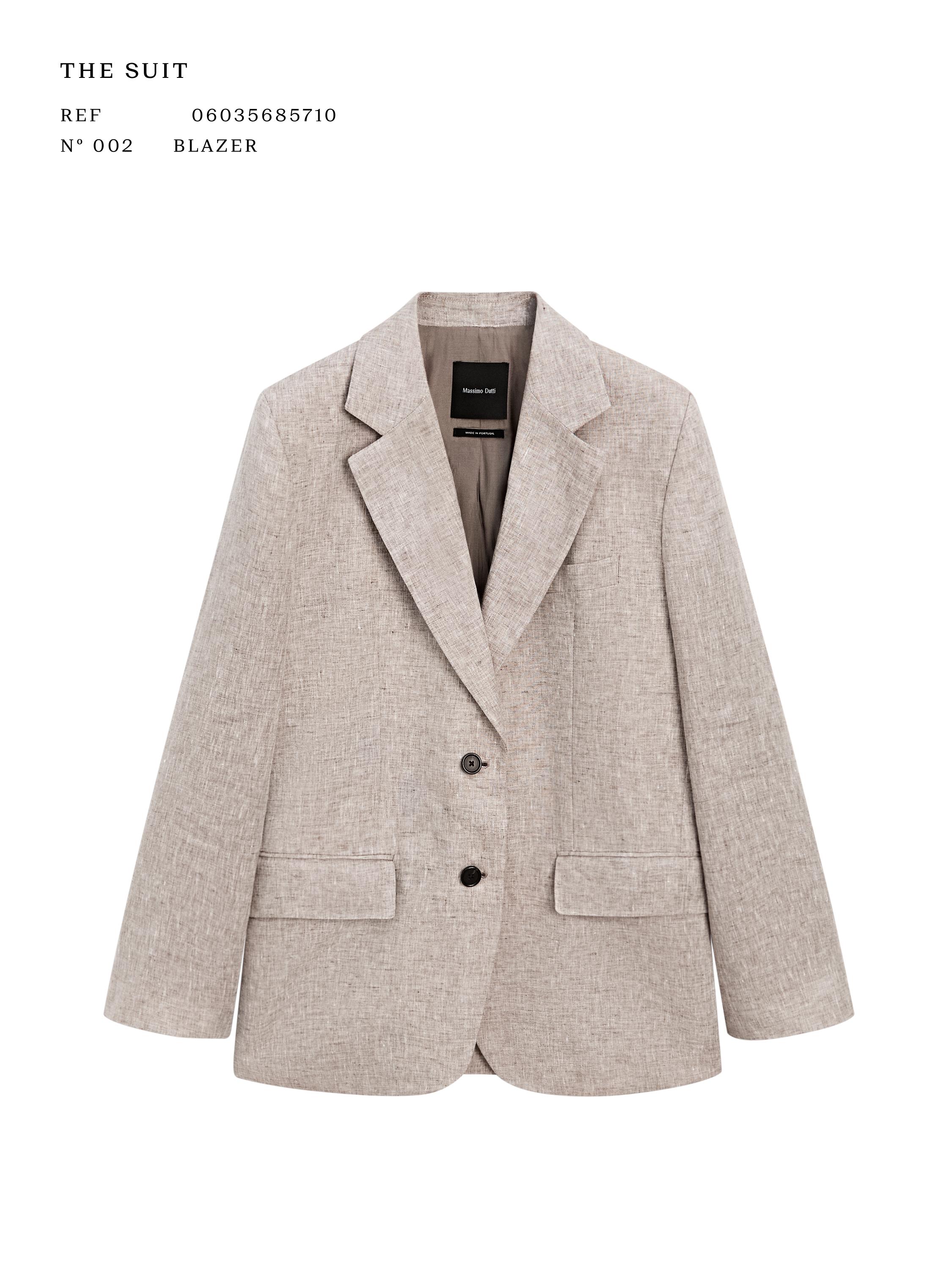 Вид спереди на бежевый блейзер с зубчатыми лацканами, двумя пуговицами спереди и карманами с клапанами. Видимый текст: "THE SUIT".