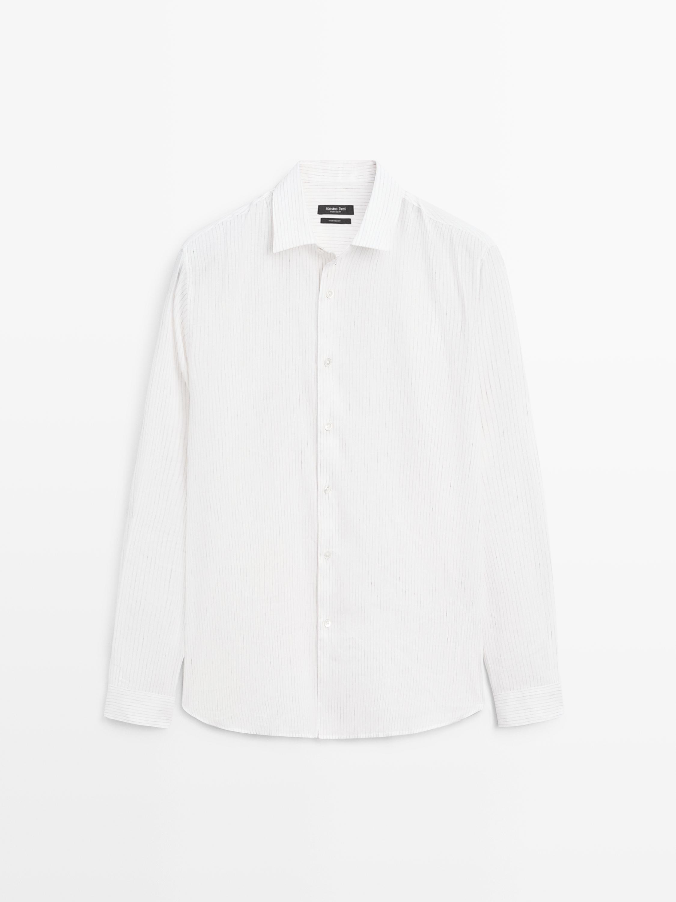 Vista frontal de camisa blanca de ratlles fines amb mànigues llargues i botonadura central.