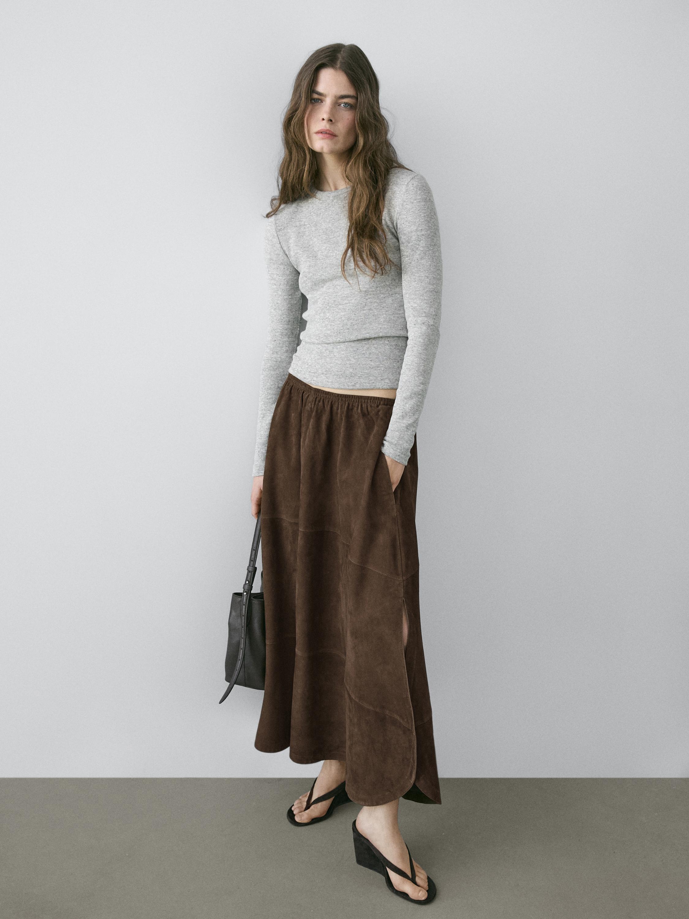 Midi-rokset in bruin met zijzakken en zijsplit, en een grijs T-shirt met lange mouwen.