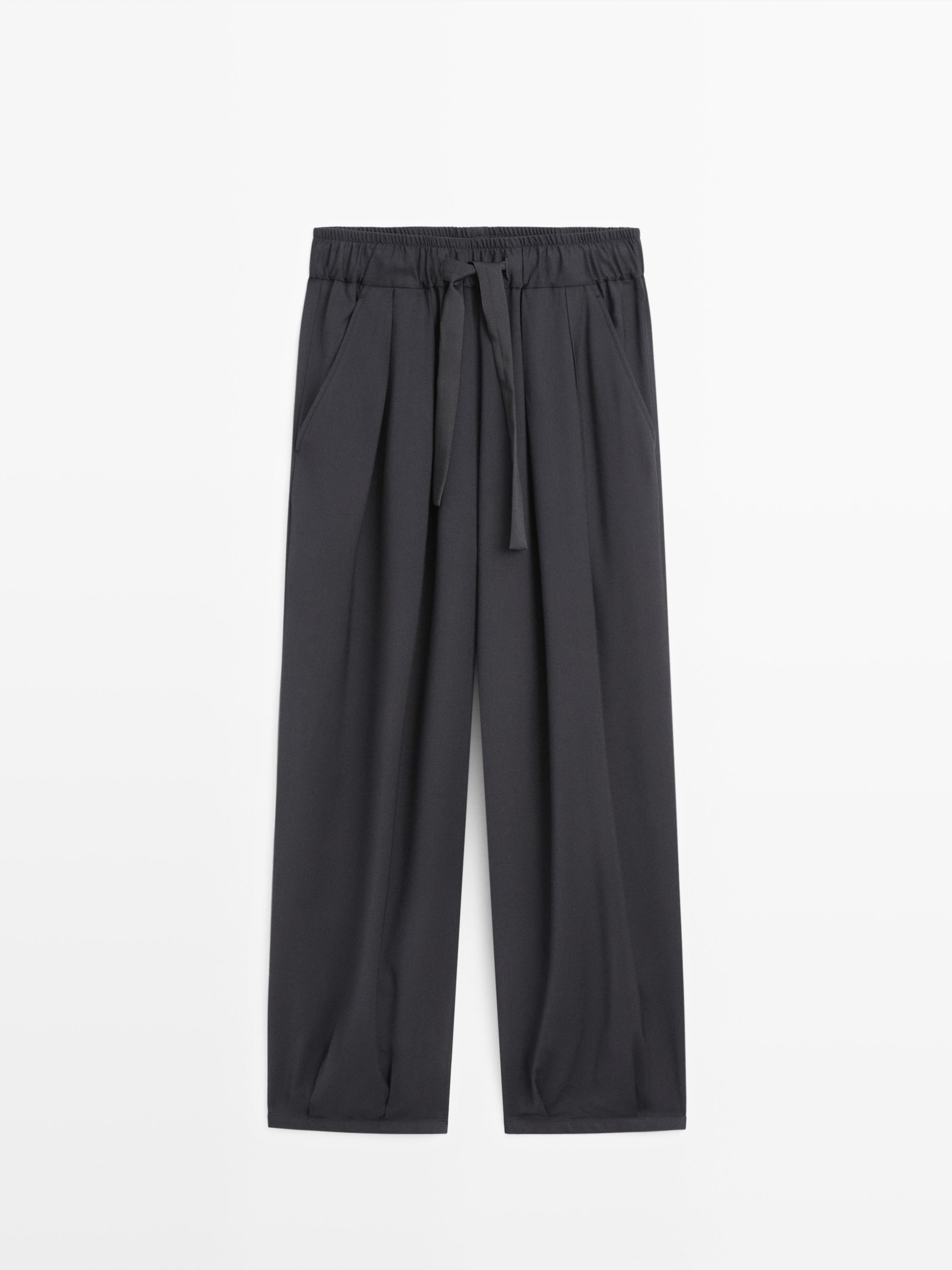 Pamje ballore e pantallonave të gjera blu marine me pala, brez elastik me lidhëse dhe xhepa anësorë.