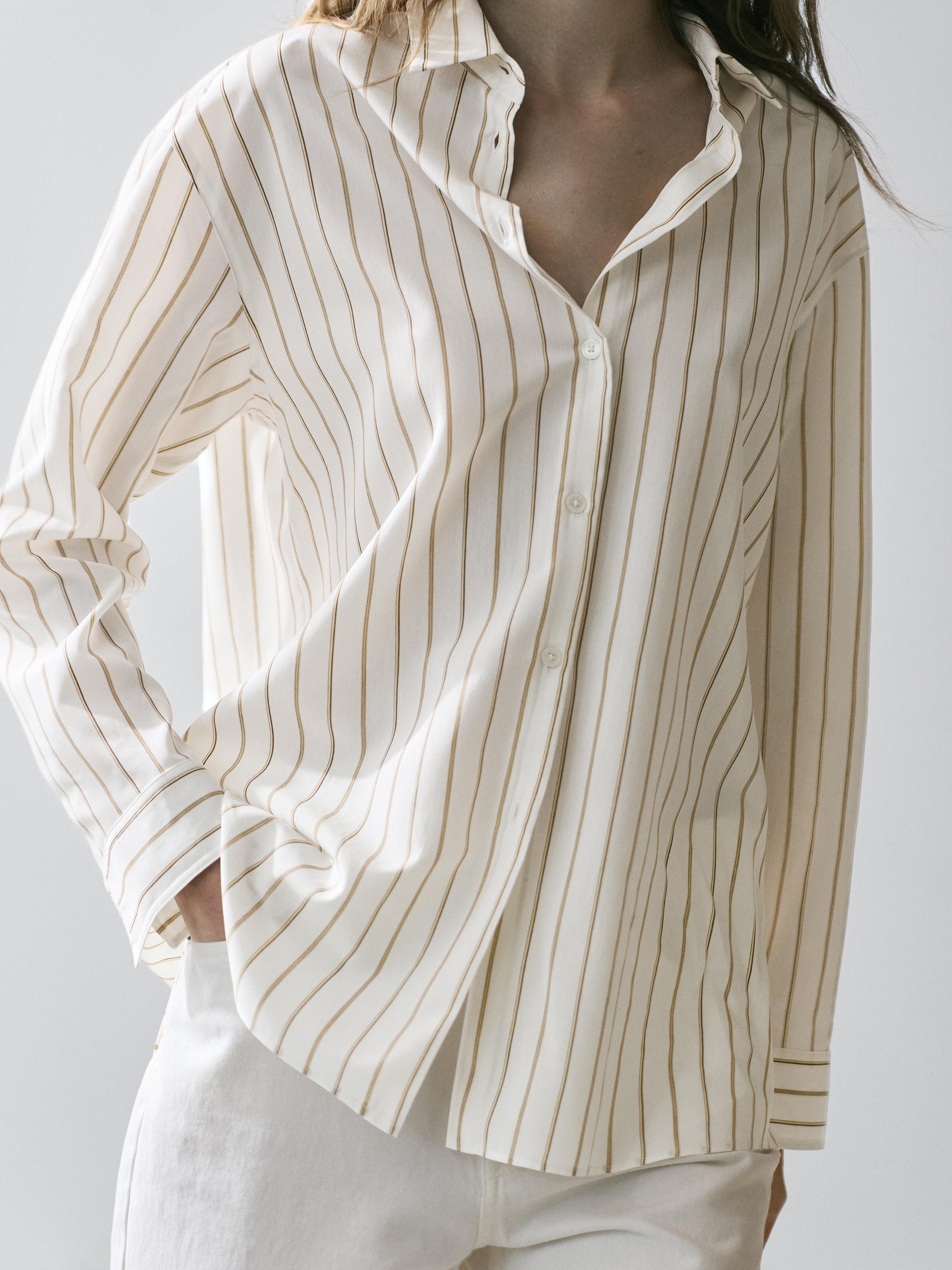Medium shot of a white shirt with tricolor stripes, classic collar, front button placket, and long sleeves. Visible side pockets.