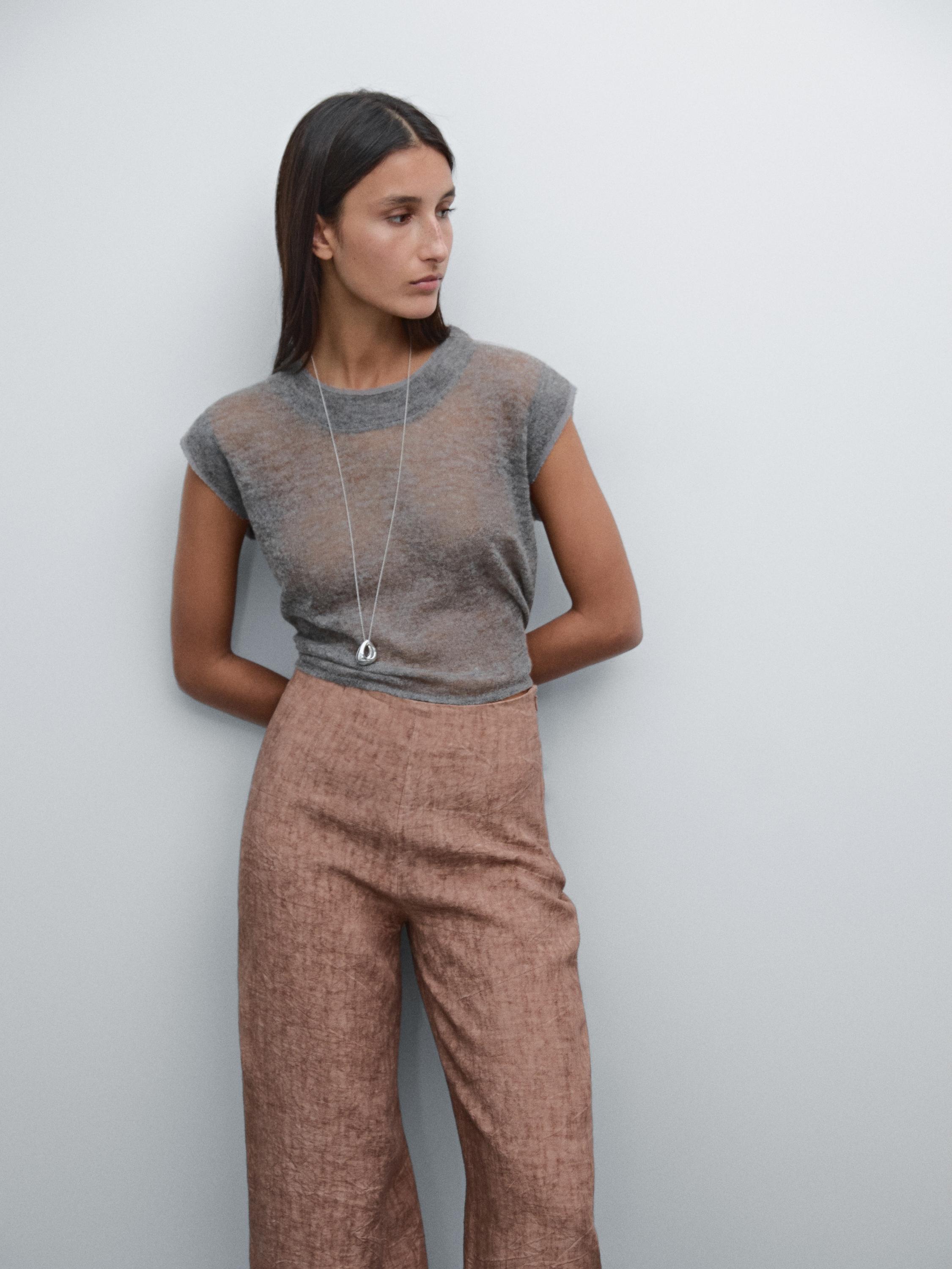 Ensemble composé d'un t-shirt gris transparent et d'un pantalon marron clair.