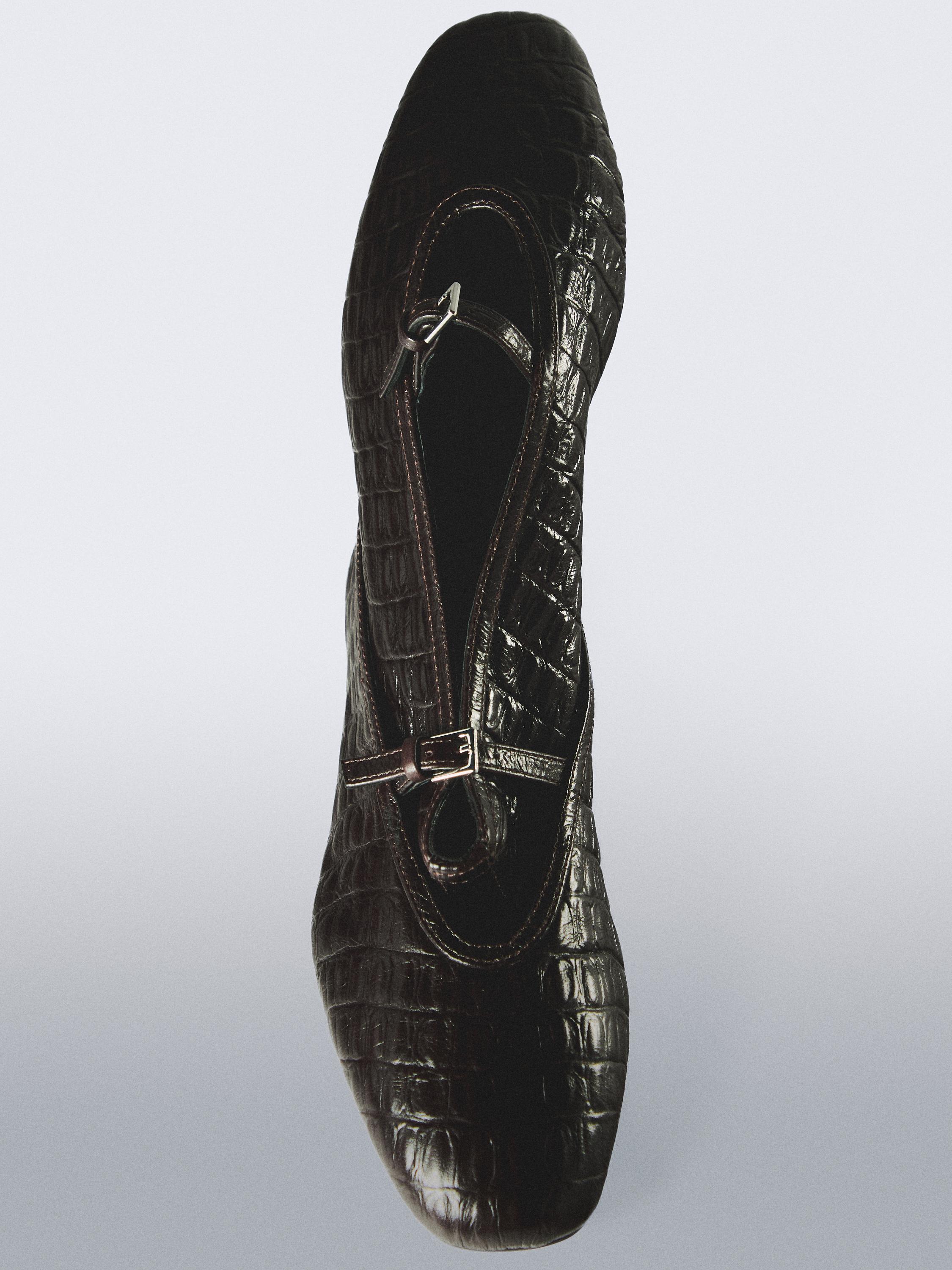 Vista superior de bailarina marrón con textura de cocodrilo y cierre de hebilla en el empeine.