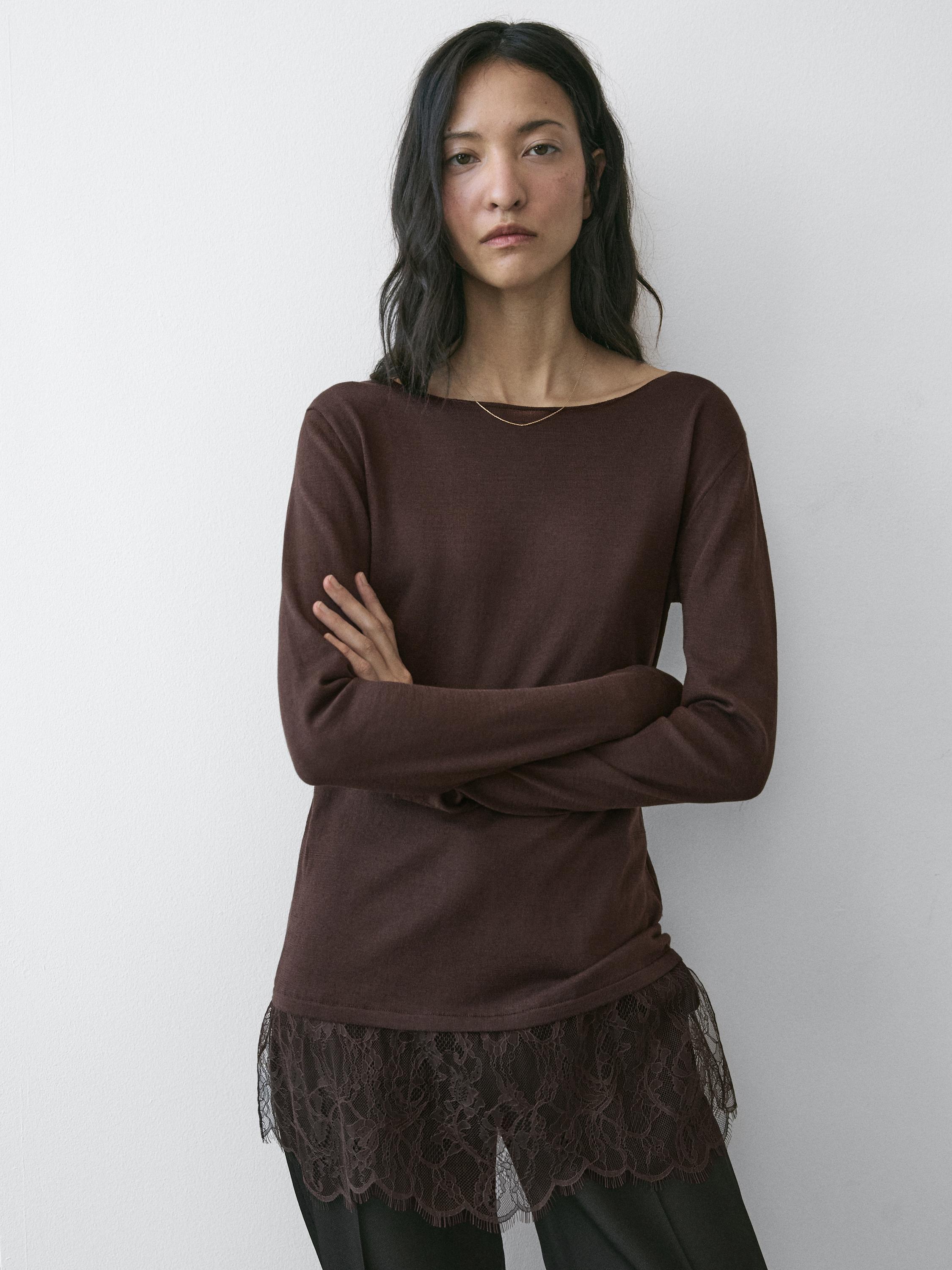 Zestaw składający się z brązowej koszulki z długim rękawem z koronkowym detalem na obszyciu, połączonej z czarnymi spodniami.