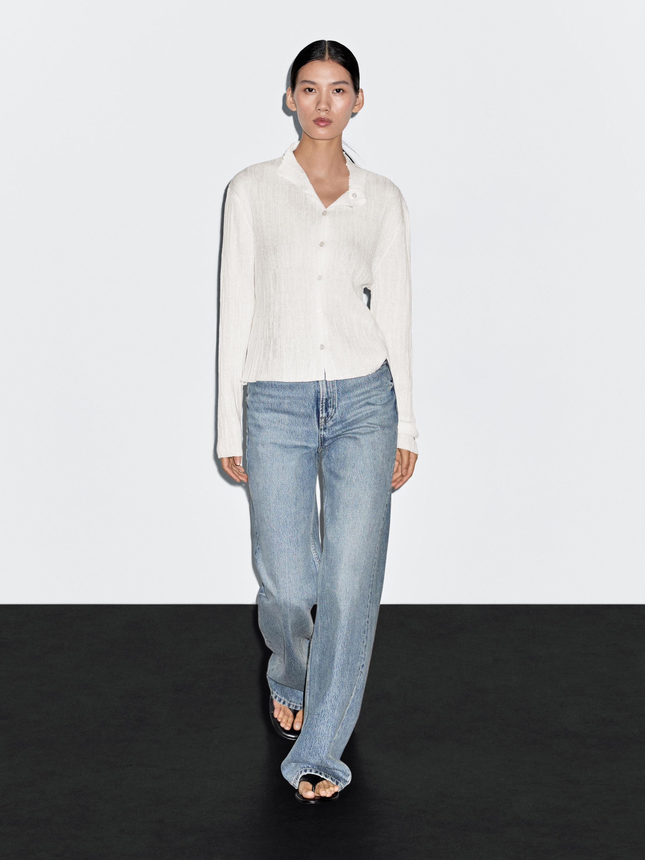 Conjunto de cárdigan crudo con textura y botones, y jeans azules de corte recto.