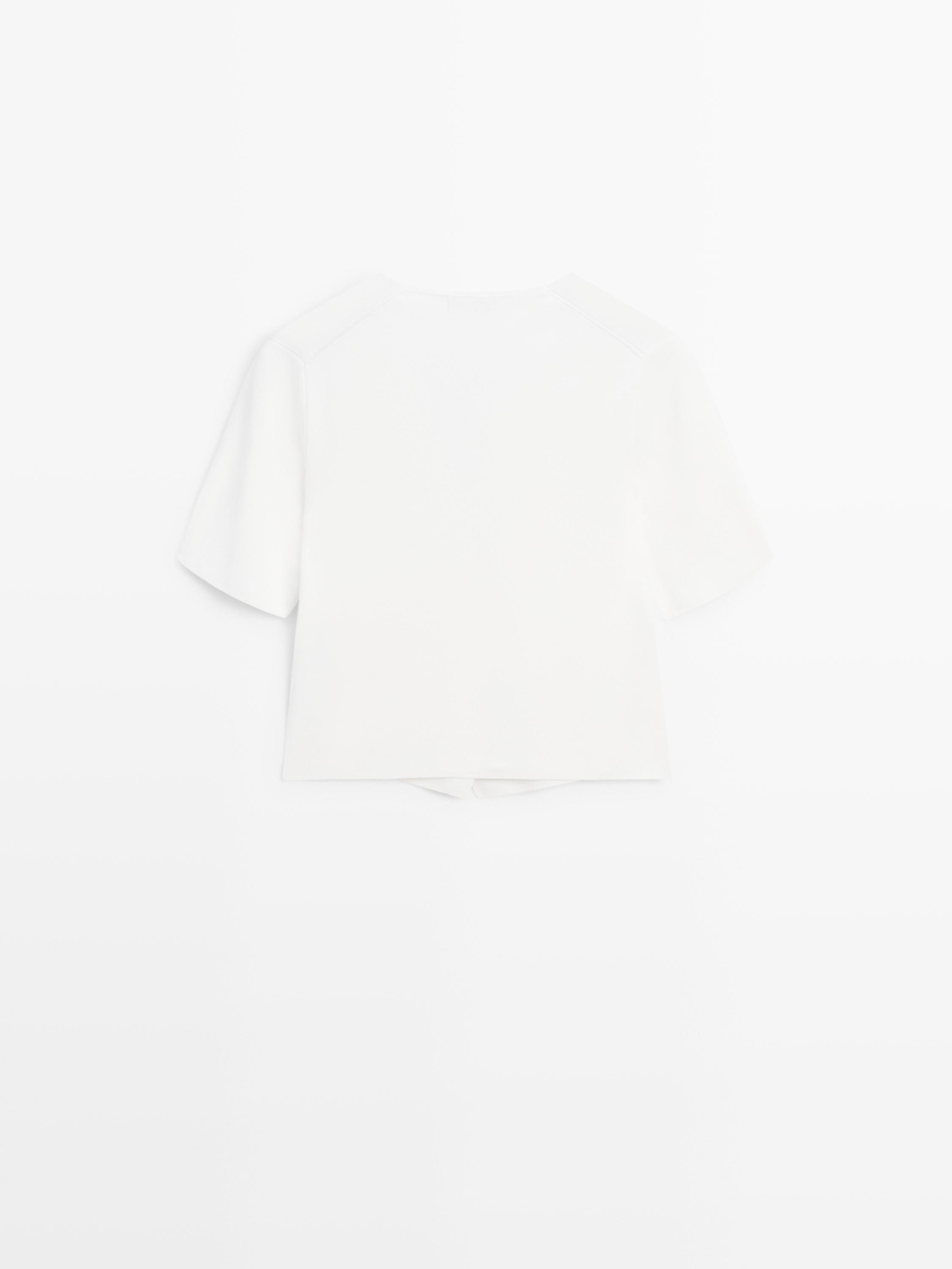 Vista posterior de un cárdigan blanco de manga corta.