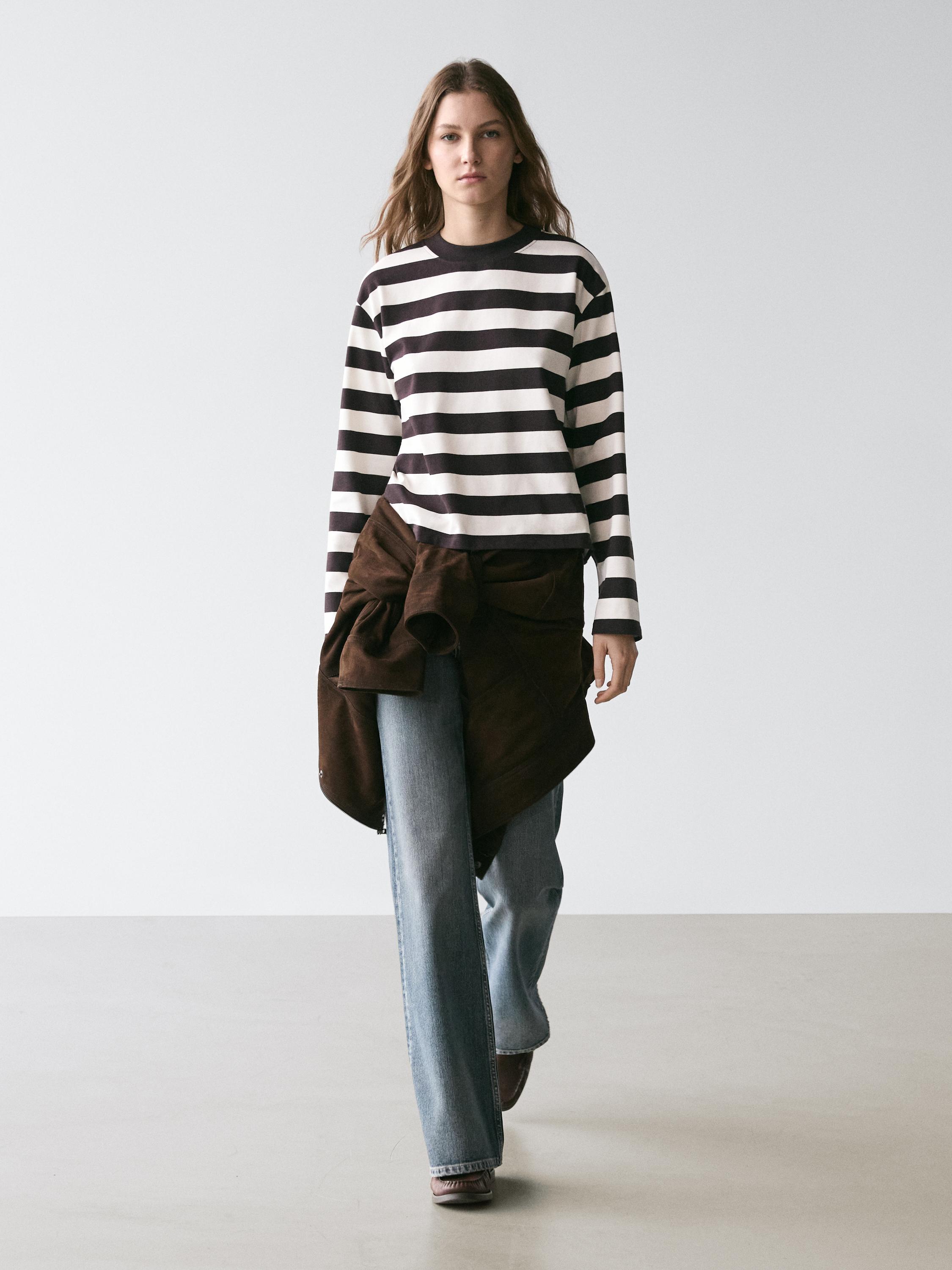 Brown and white striped long-sleeve t-shirt set, wide-leg jeans, and brown jacket tied at the waist.