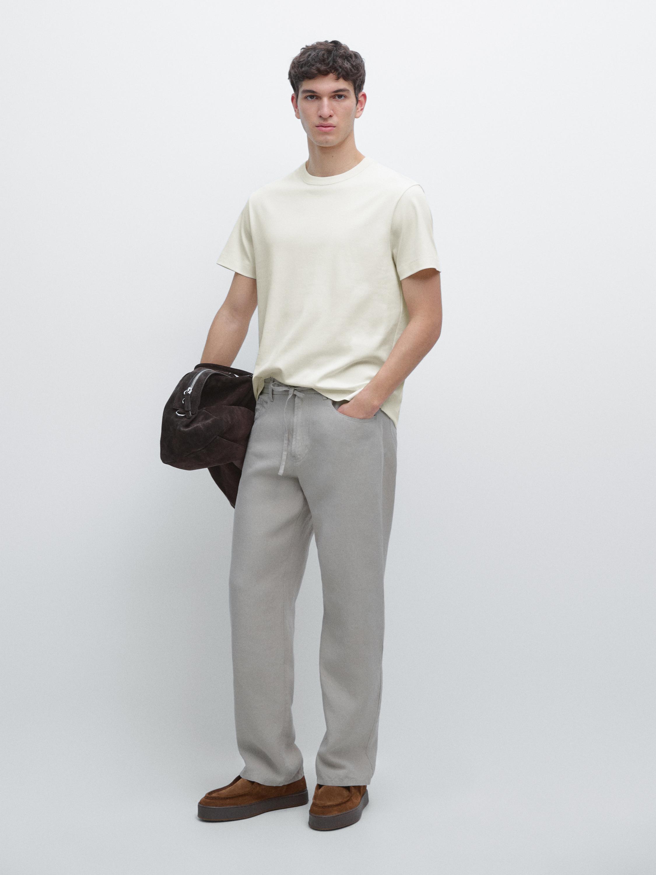 Beige short-sleeved T-shirt and gray pants set with side pockets.