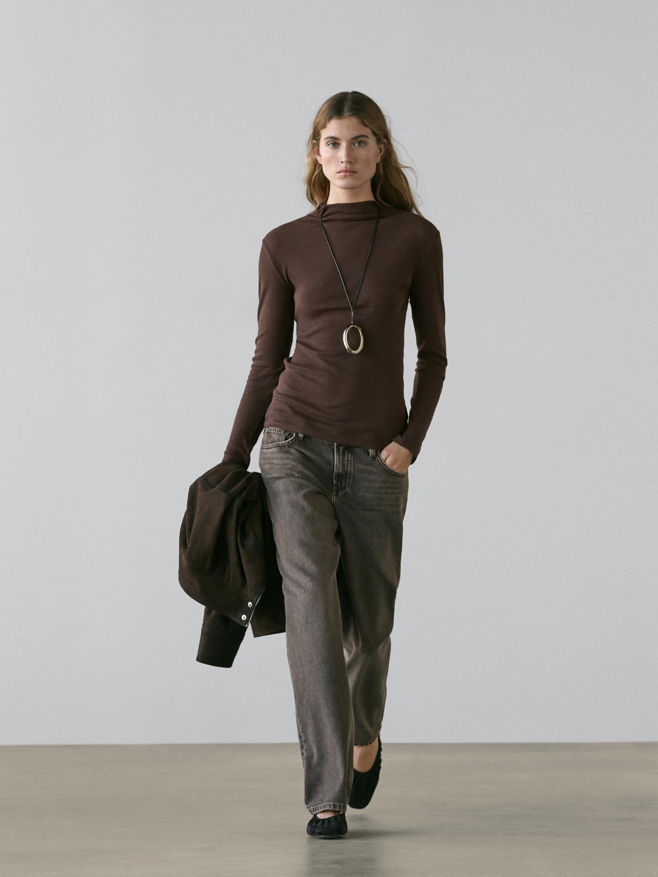 Conjunto de playera café de manga larga y pantalones de mezclilla grises con bolsillos delanteros.