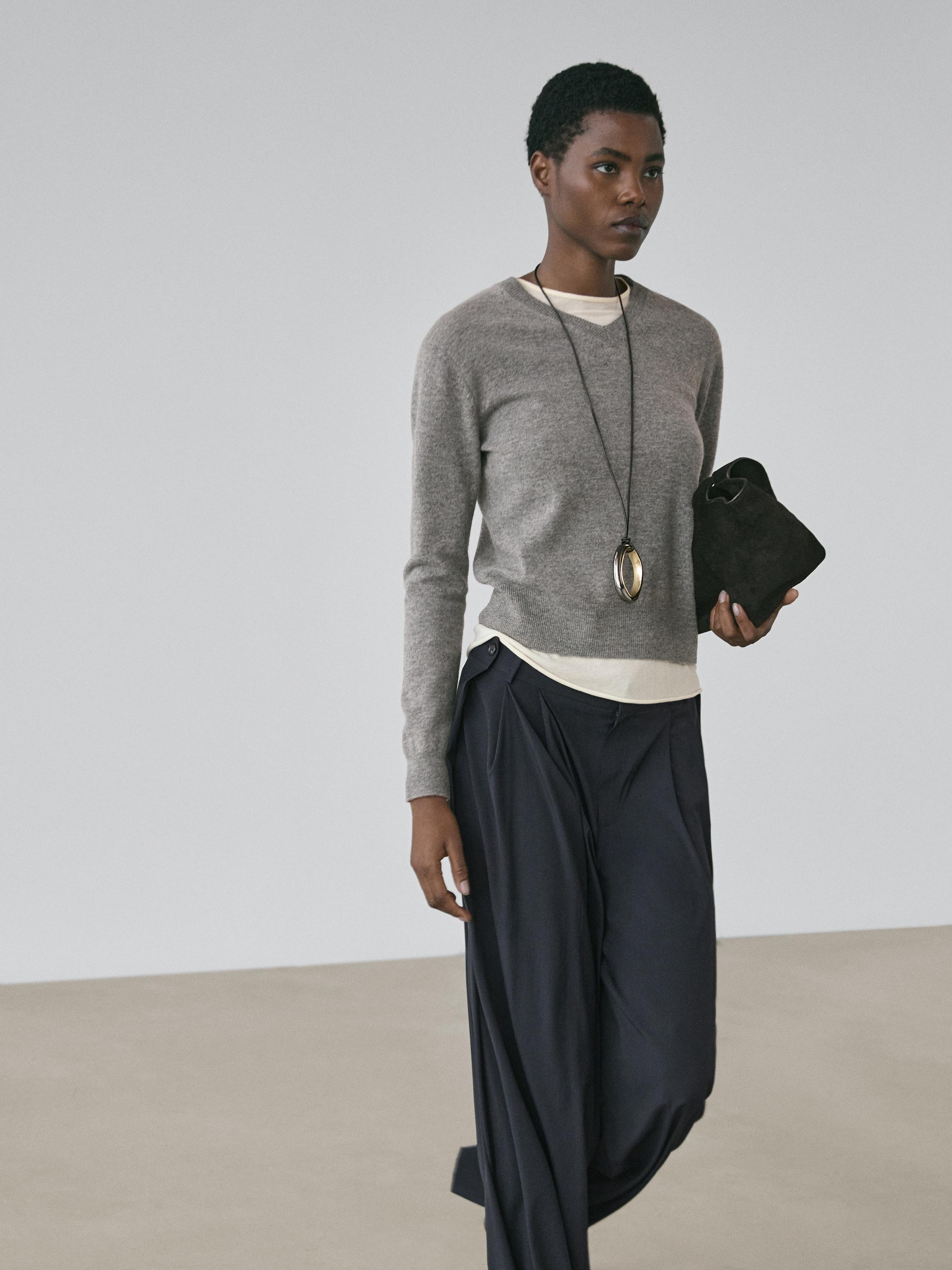 Gray sweater and navy blue pleated pants set.