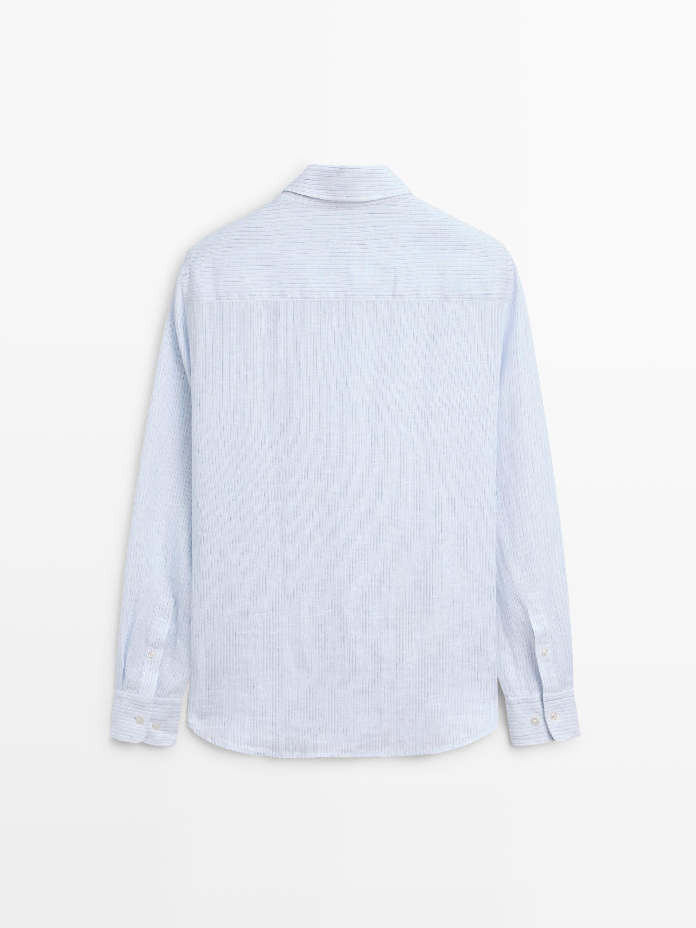 Vista posterior de camisa azul celeste de manga longa con puños abotoados e corte regular.