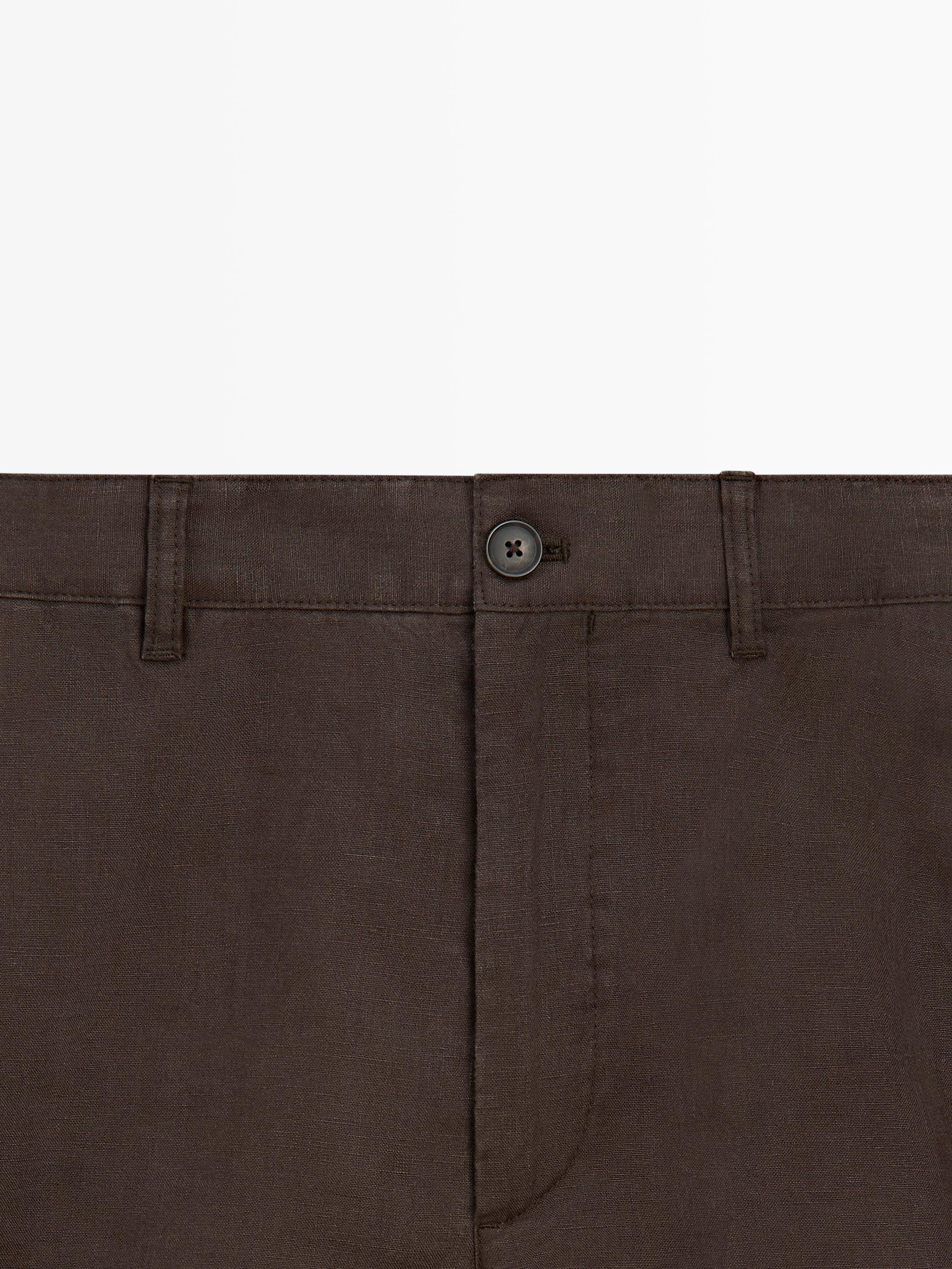 "Plano medio de bermuda café con botón frontal y presillas para cinturón."