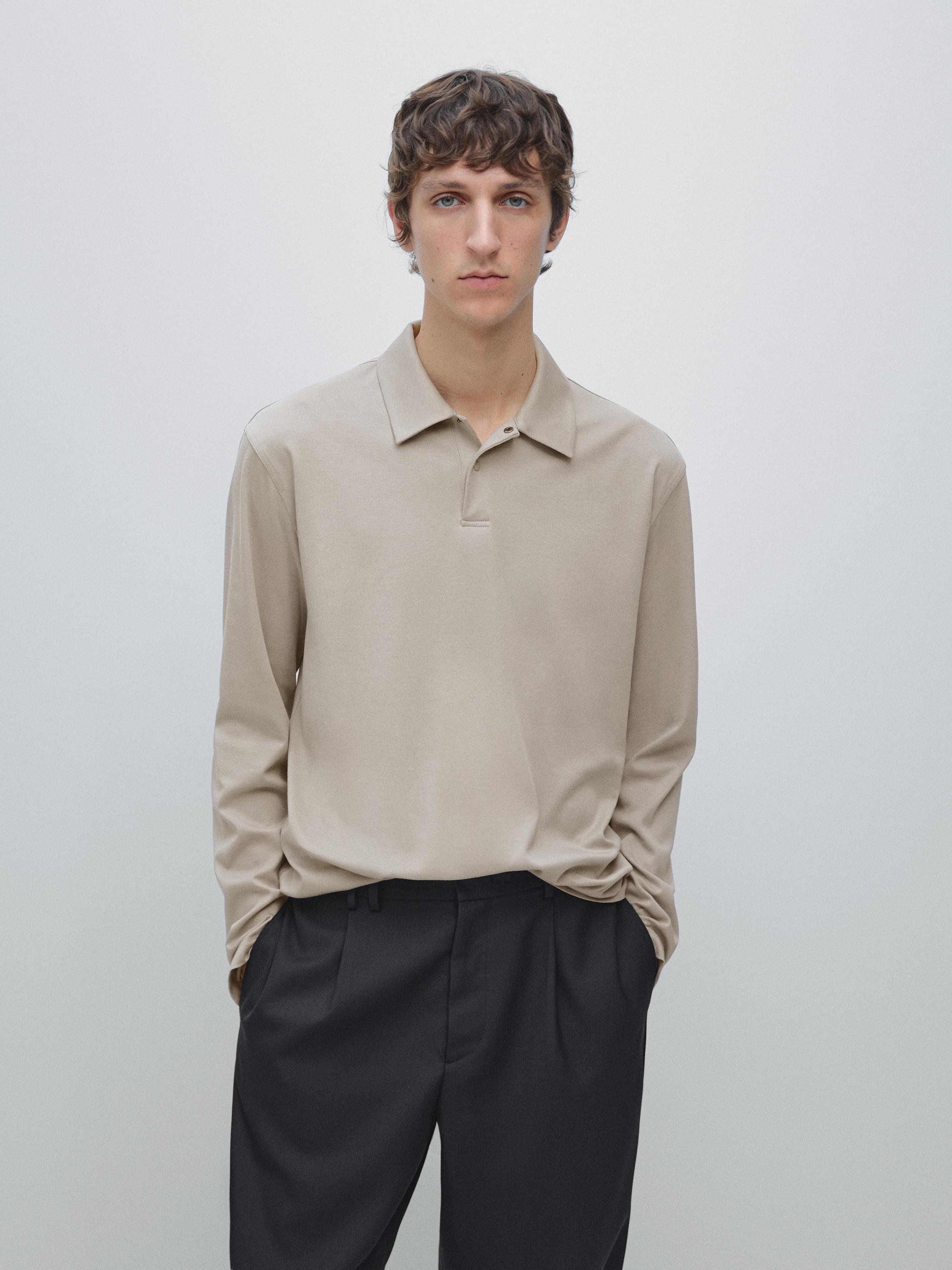 Ensemble polo pierre à manches longues avec bouton pression et pantalon noir.