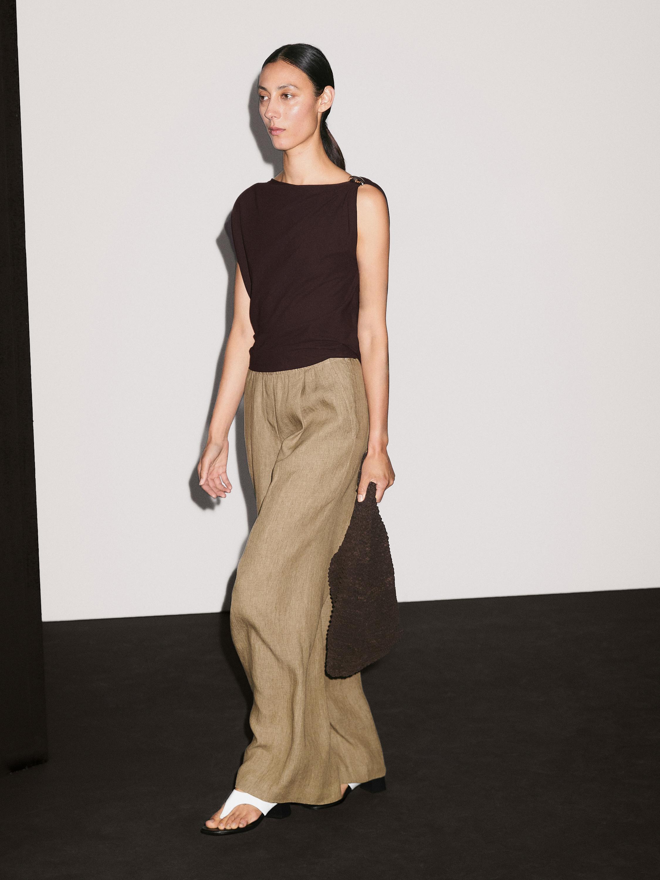 드레이프 네크라인 탑에 브로치 디테일이 있는 상의