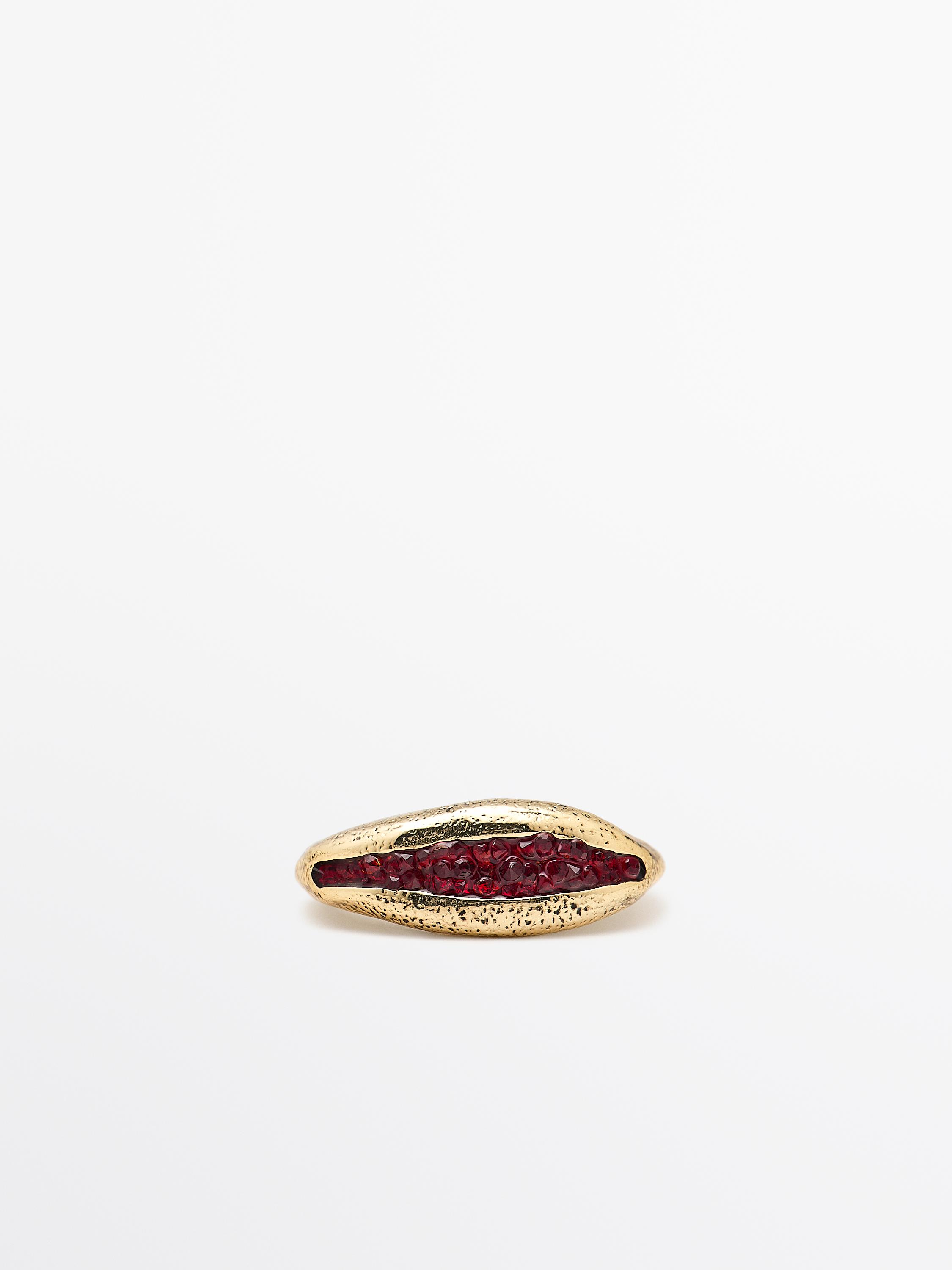 Gold ring with irregular design and bright red central detail.