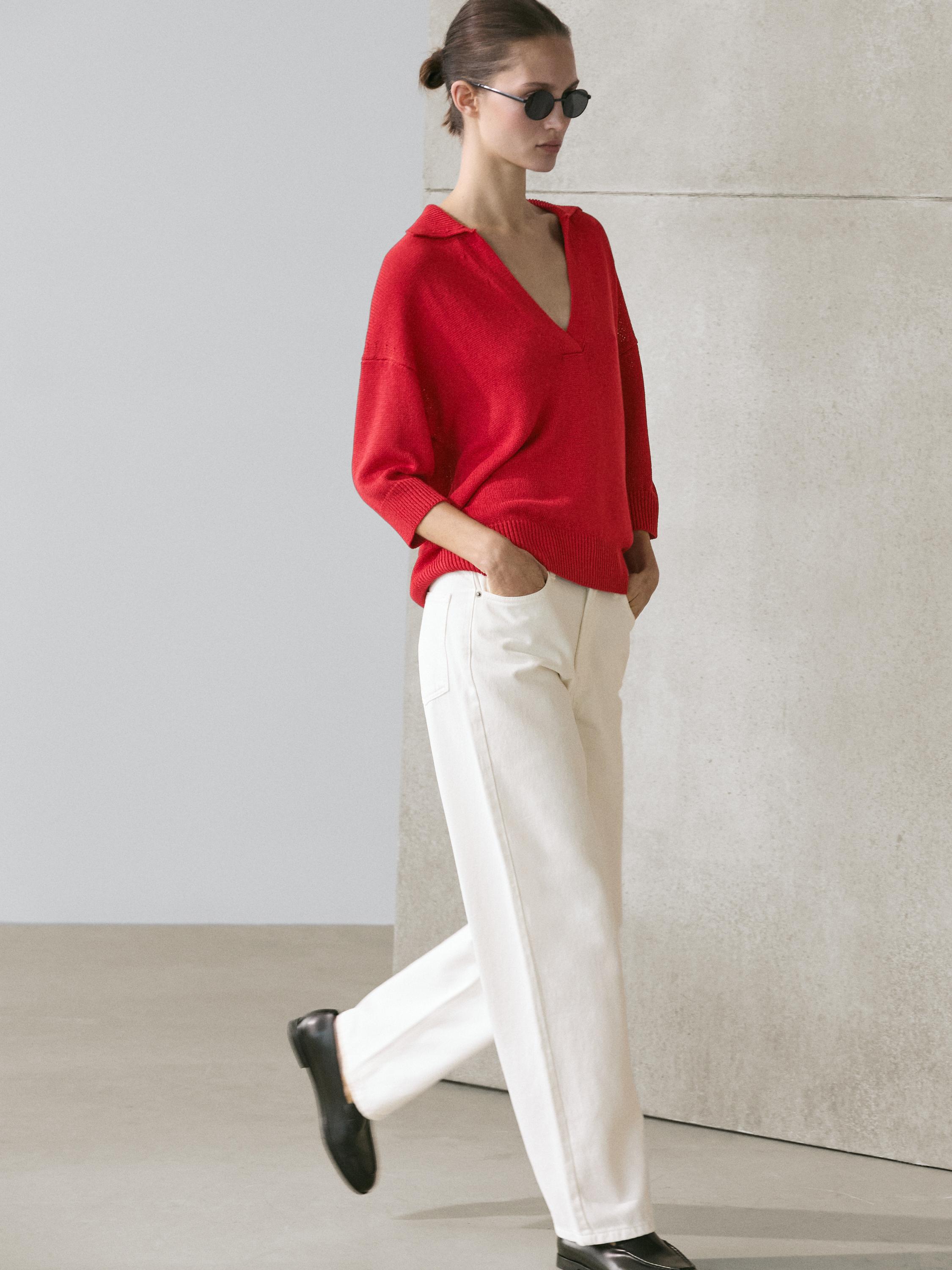 Fluid knit red polo neck sweater set with straight white pants with side pockets.