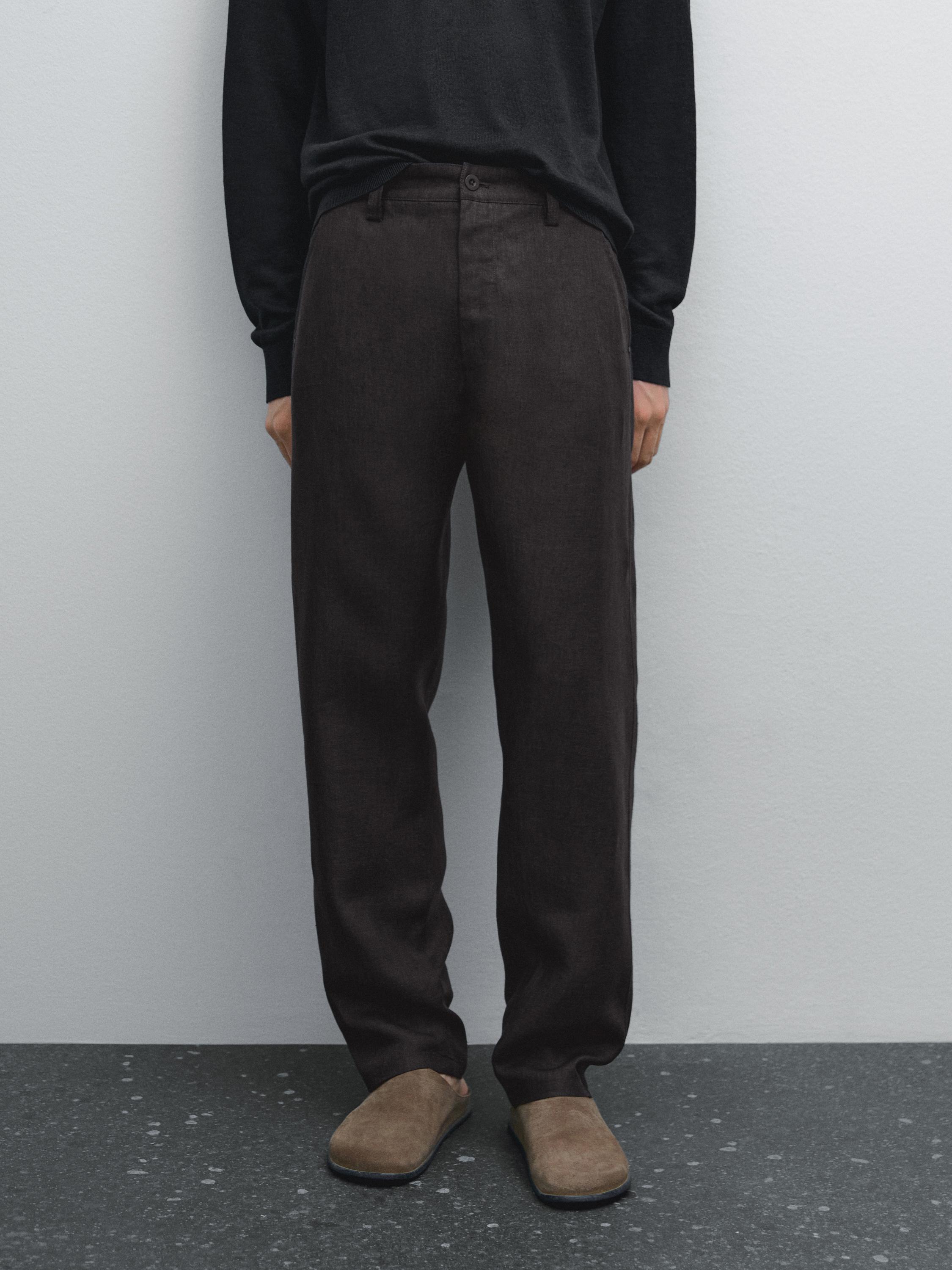 Ensemble composé d'un pantalon foncé avec des poches latérales et de chaussures marron.
