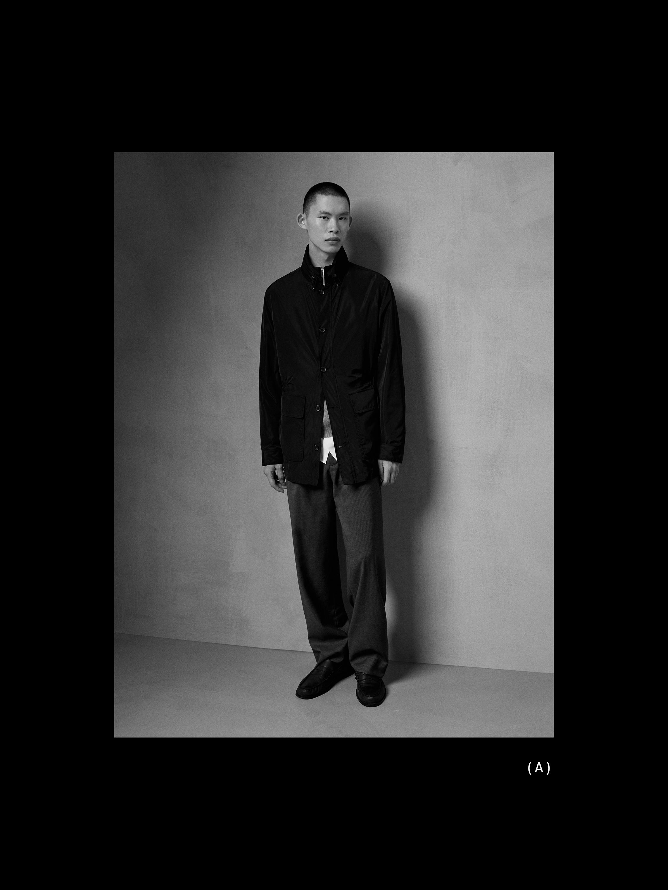 ชุดสูท เสื้อแจ็คเก็ตสีดำมีกระดุมและกระเป๋าด้านหน้า กางเกงขายาวสีเข้ม และรองเท้าสีดำ