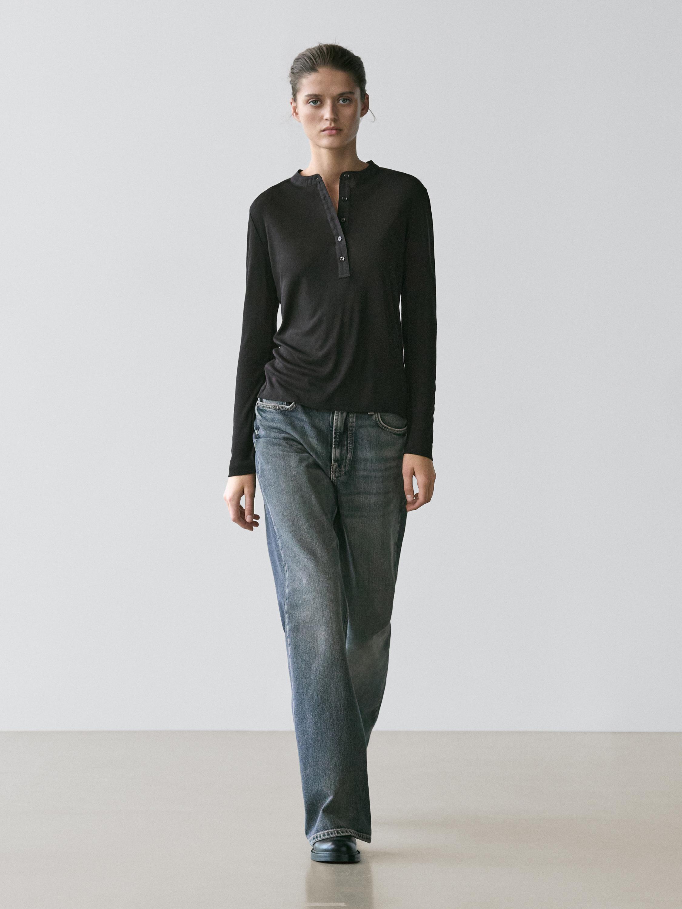Black long-sleeve henley shirt and straight-leg blue jeans set.