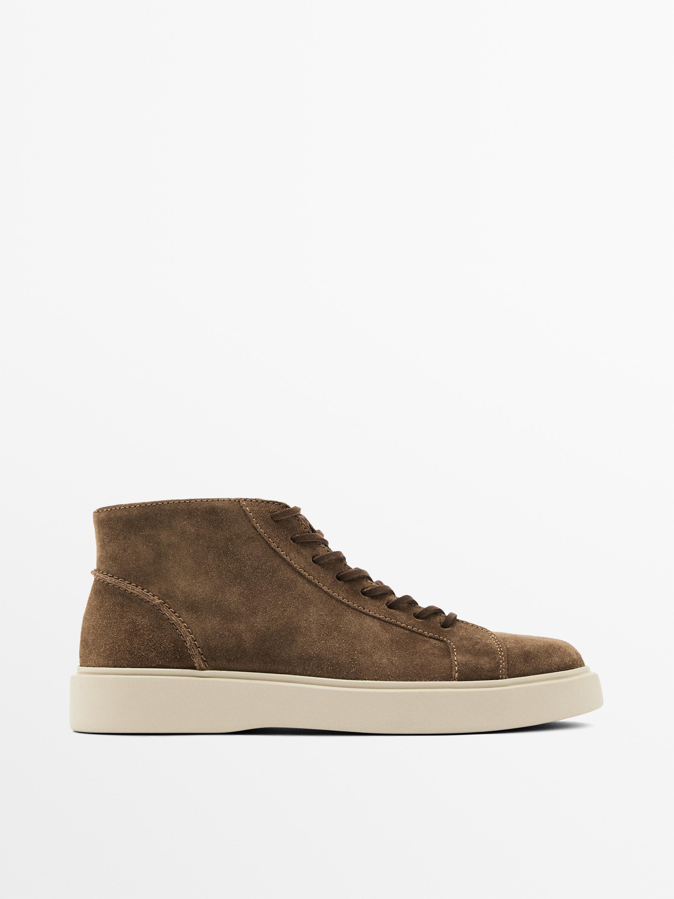 "Side view of a brown, lace-up, ankle-high sneaker with a thick white sole."