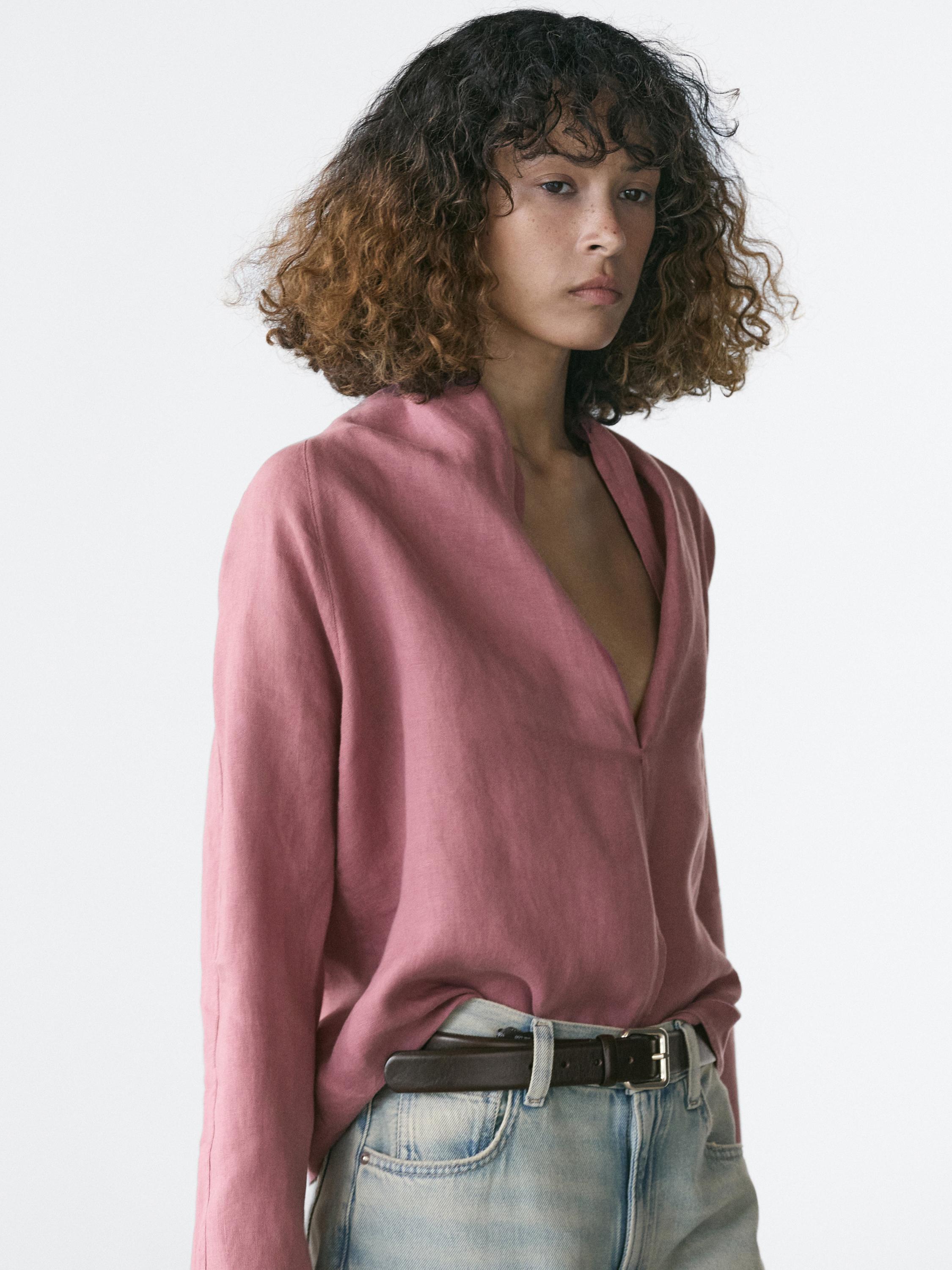 Plano medio de blusa rosa cruzada con cuello en V y mangas largas.