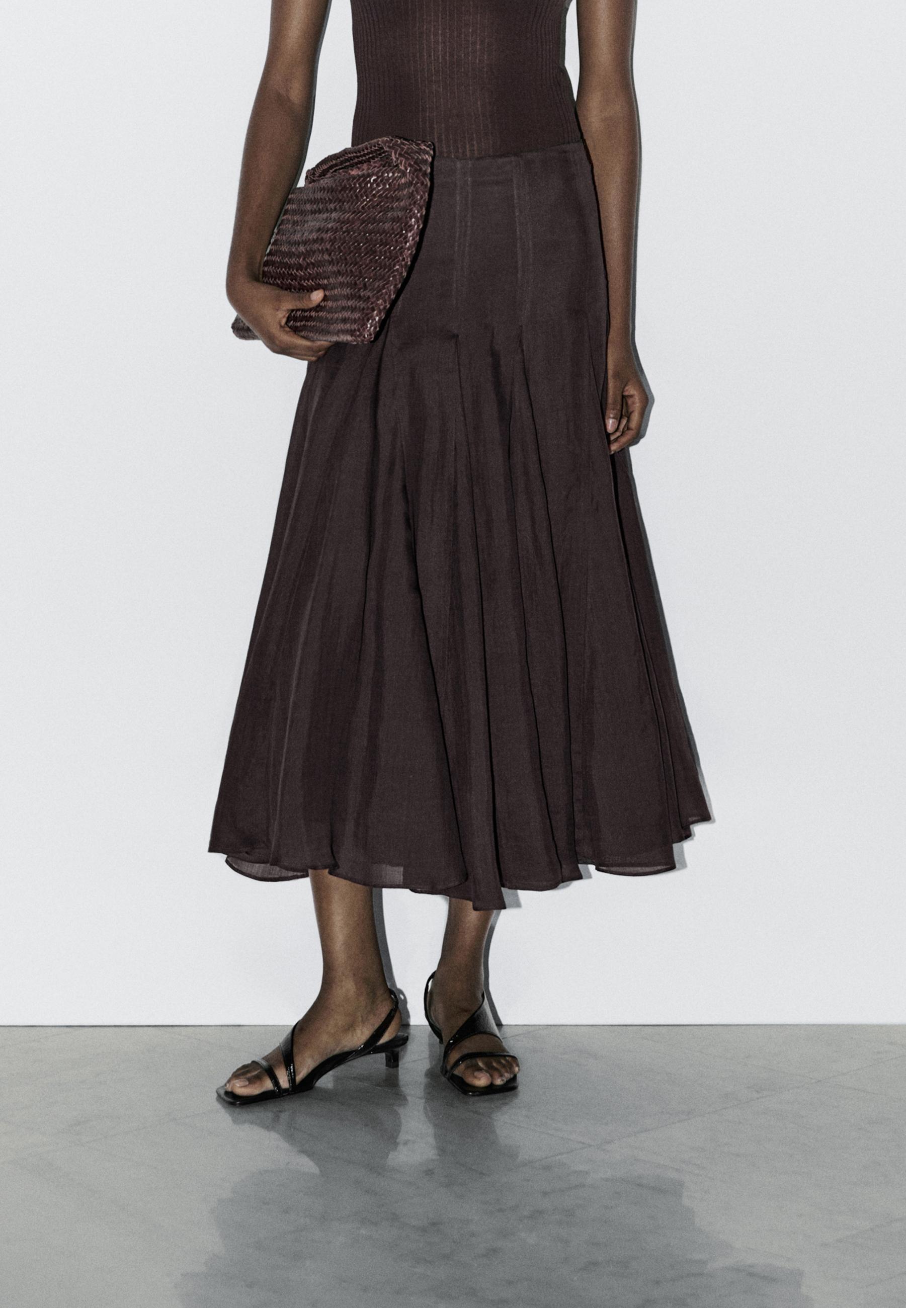 Lilac pleated godet midi skirt and black low-heeled sandals outfit.