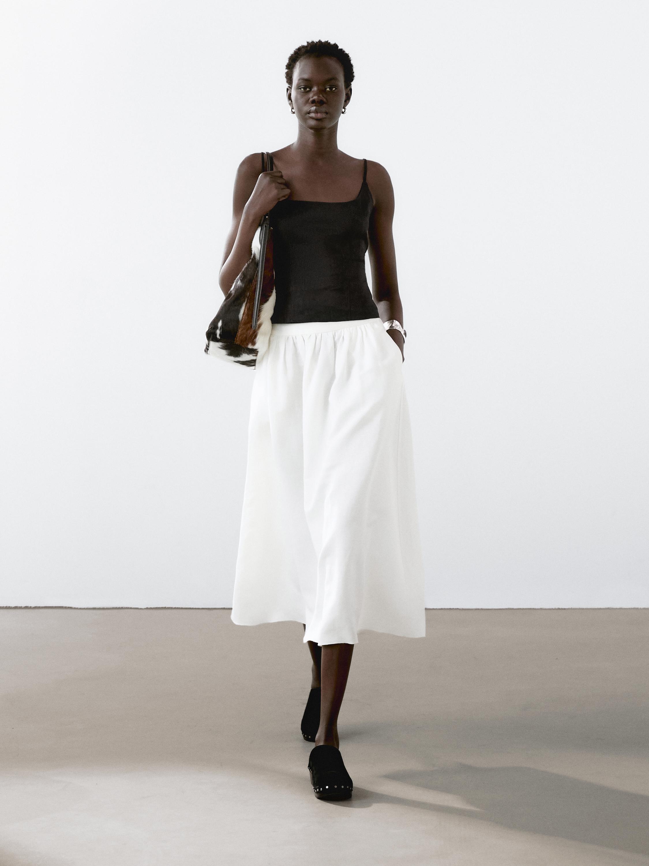 Conjunto de top negro de tirantes y falda blanca larga