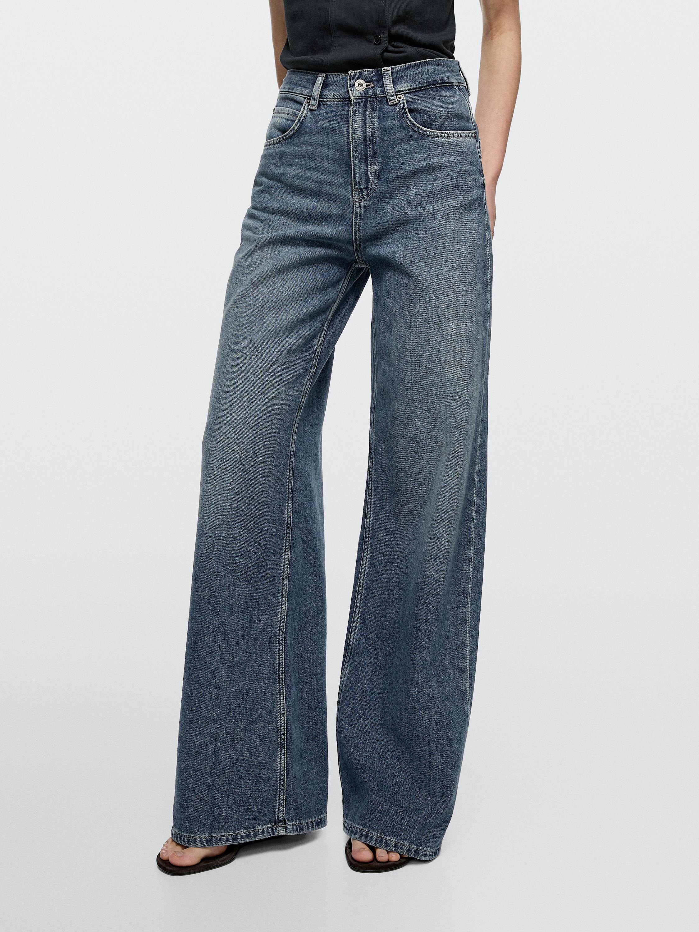 Conjunt de texans blau mitjà wide leg de tir alt amb butxaques davanteres i posteriors visibles.