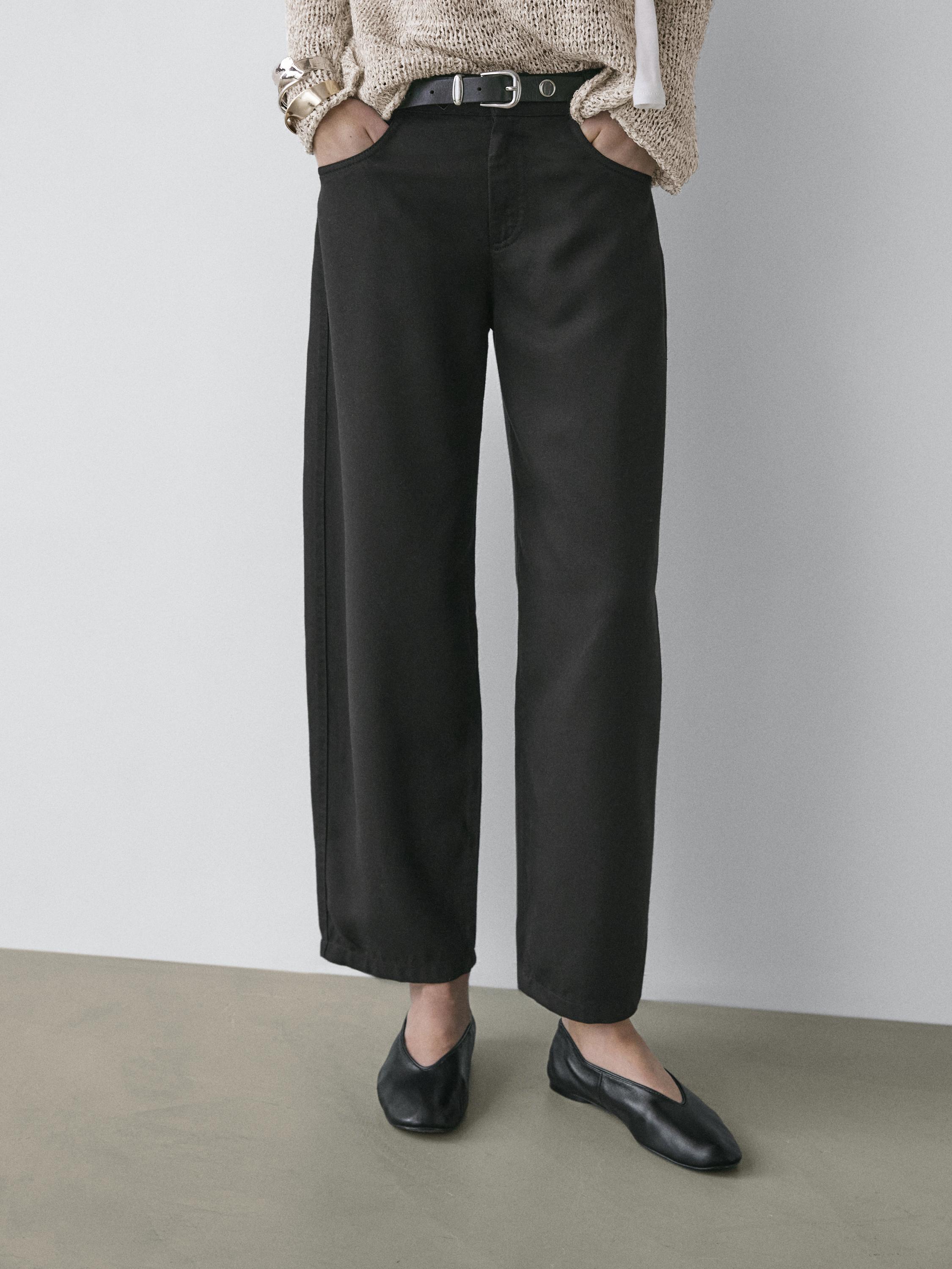 Completo di pantaloni neri a taglio barrel fit con tasche laterali e cintura nera.