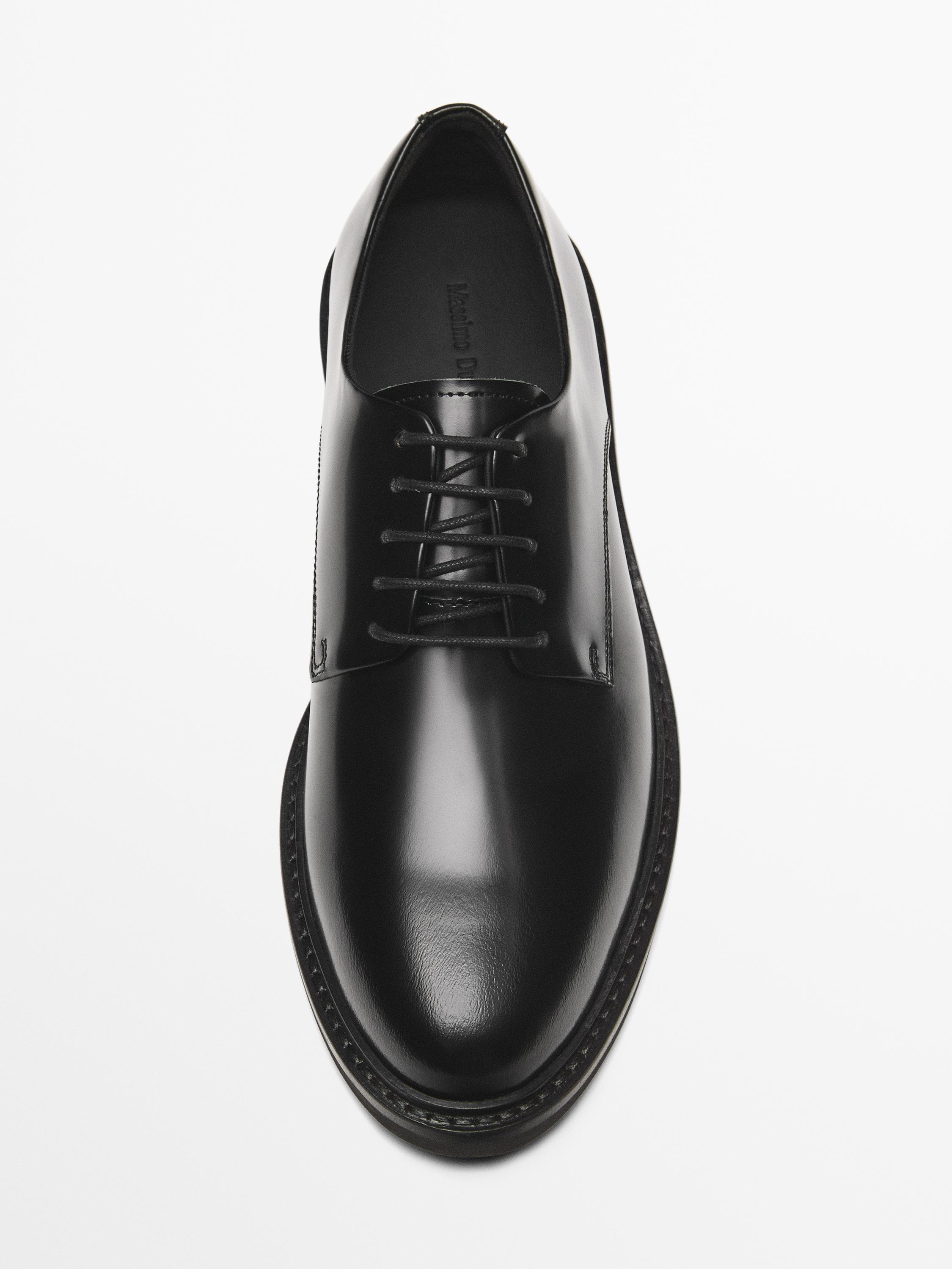 Top view of black lace-up oxford shoe.