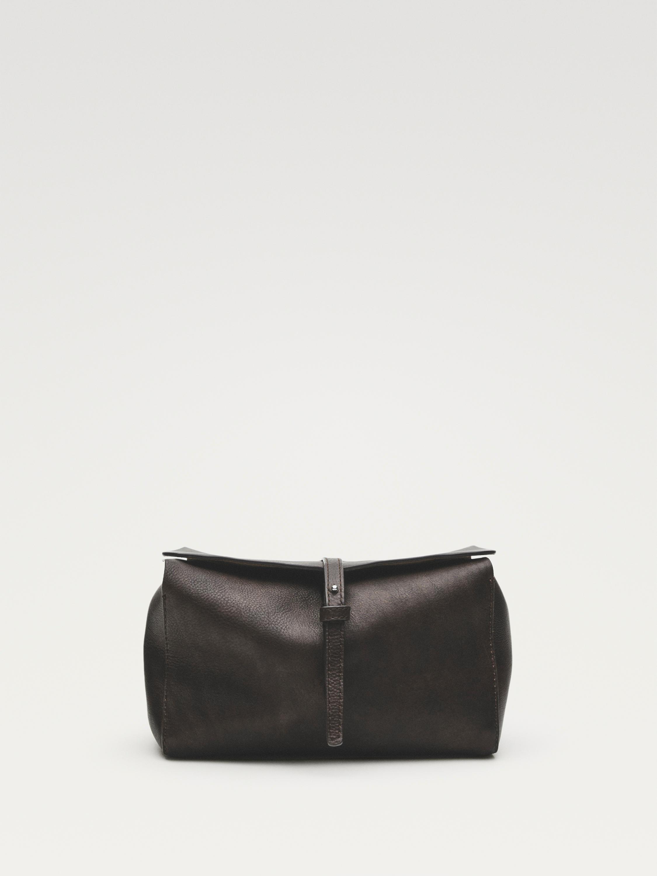 Vista frontal de neceser café con cierre de correa y hebilla.