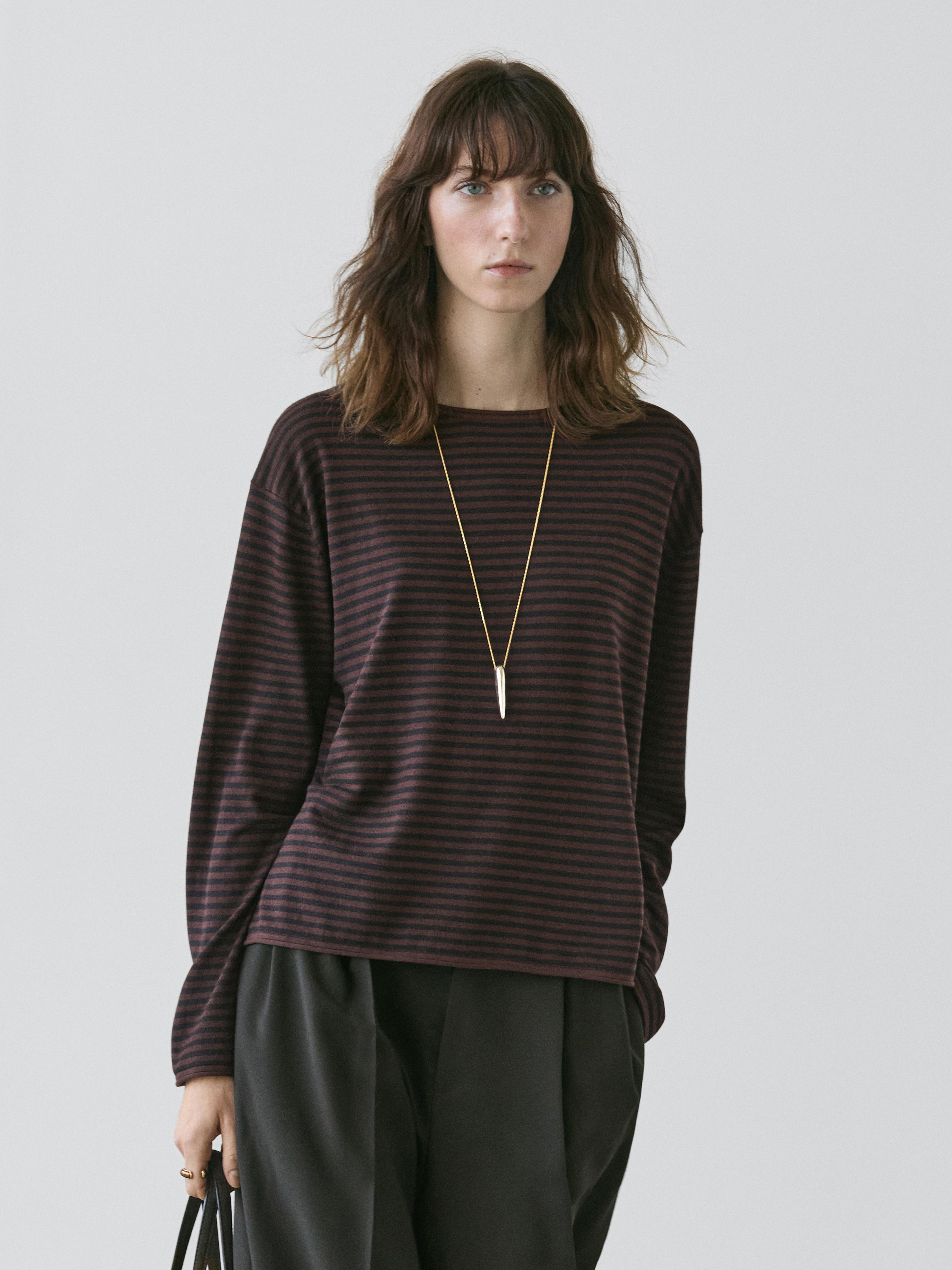 Brown striped crewneck sweater and loose black pants set.
