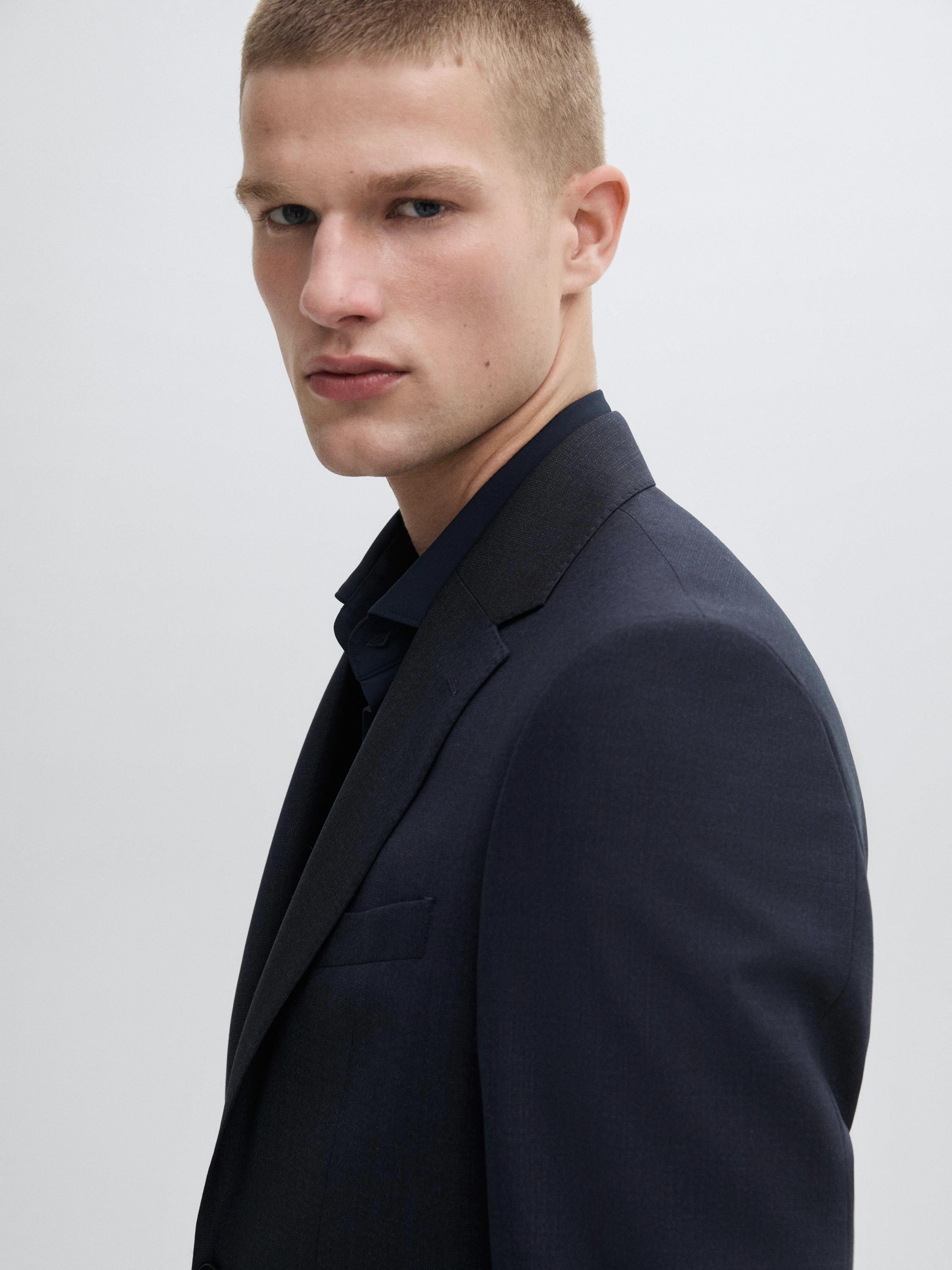 لقطة مقرّبة لسترة كحليّة بياقة كلاسيكية وظهور ياقة القميص.