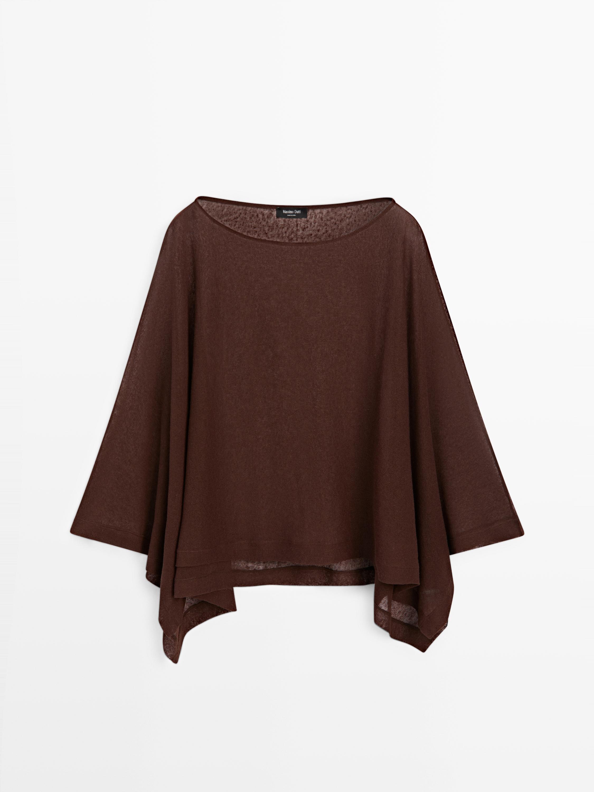 Geniş kesimli ve asimetrik etekli uzun kollu kahverengi topun önden görünümü.