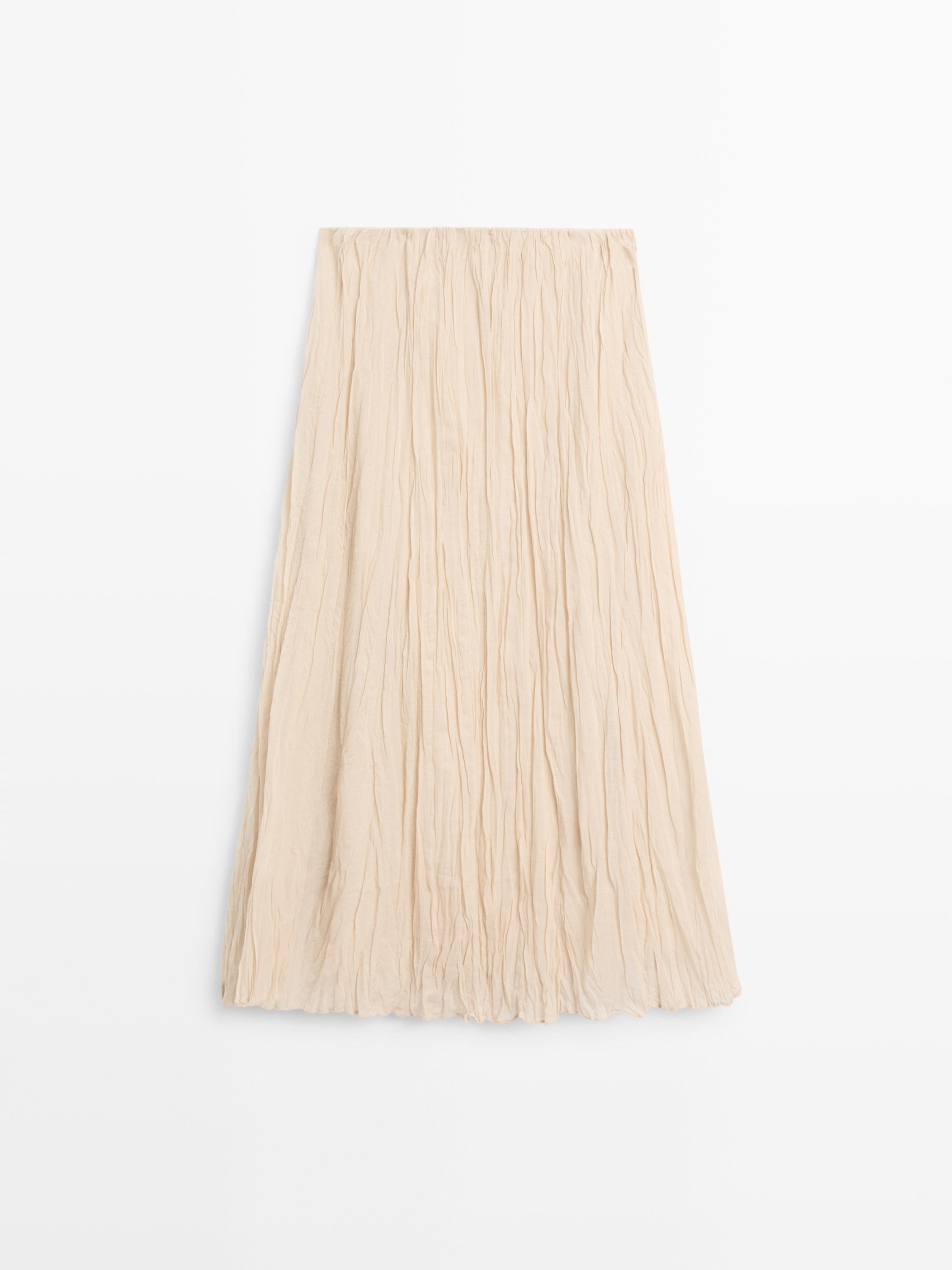 Vista frontal de saia midi crúa con detalle plisiado e corte fluído.